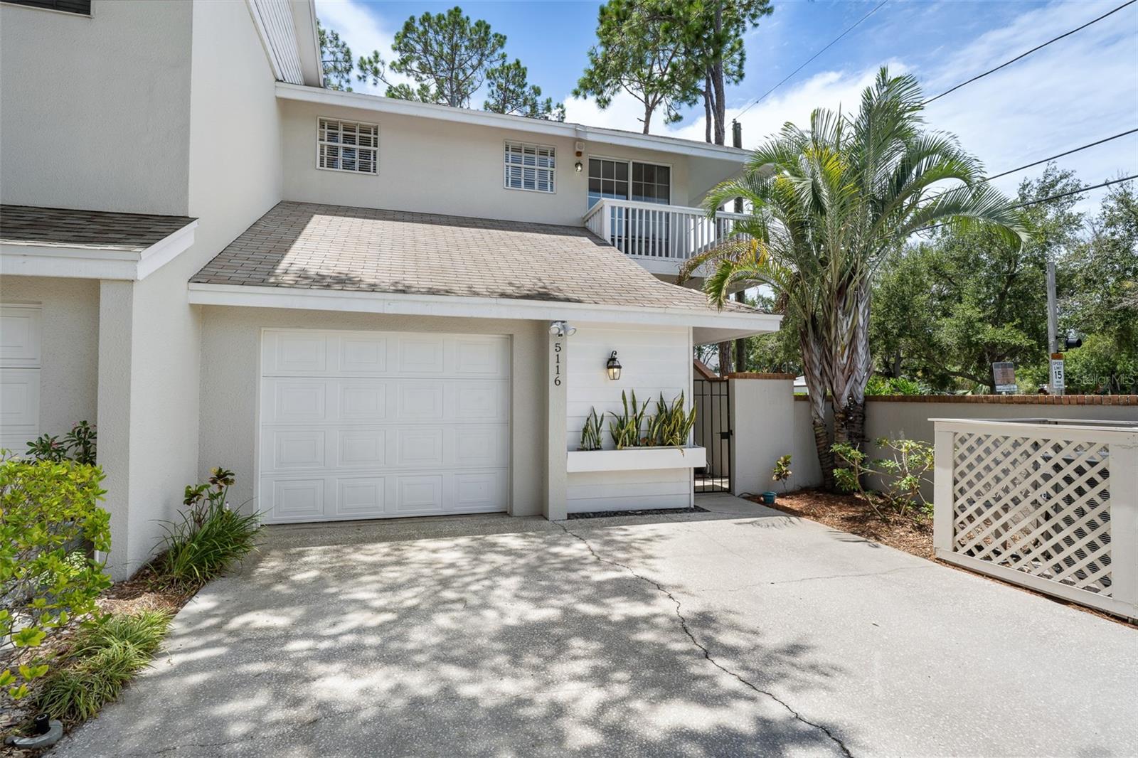 A immaculate corner unit at Colony Key is available. It is in excellent condition. The entryway to the unit is through a private gate and courtyard. A nice porch leads to the front door and once inside a foyer will take you to a half bath and then the hallway to the rest of the interior. The hallway also opens to the garage off to the left. The single car garage is oversized and has finished floors and loft storage area (10x9). Lots of storage is in the garage. Back inside to the hallway with the wood floors. The hardwood floors that are downstairs and on the 
stairwell leading to the second level and also on the landing upstairs are in beautiful condition. These floors lead to the kitchen which features stainless appliances, lots of solid wood cabinets and a pull down table for breakfast. There are stairs from the hall leading  down to the a large living room with a wood burning fireplace and a decorator built in wine cabinet.The dining room is off the living room and both rooms are adjacent to the first of three balconys. At the top of stairs on the second floor is the laundry room. To the right is the secondary bedroom with full bath, closet and the 2nd private balcony. To the left off the landing on floor two is the spacious main bedroom and bath. It also features a large walk in closet. The bedroom overlooks balcony number 3 which like the balcony below it, overlooks a green space. This home is in move in condition and is a short distance from the landscaped community pool area. Convenient to everything from downtown, public parks, MacDill Air Force Base, Bayshore, great restaurants, grocery stores, the beaches and shopping.