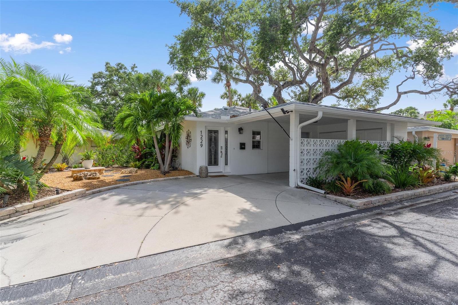 Renovated in 2025 and offered fully furnished, THIS FREE STANDING VILLA ON SIESTA KEY IS TRULY TURN KEY-ideal as a personal retreat or a high-demand seasonal rental.  Nestled in the highly desirable Polynesian Gardens along the Intracoastal Waterway, this villa offers a rare combination of privacy and convenience. One of only ten villas overlooking the expansive community pool, enjoy your own private entrance just steps from the fresh air terrace and screened lanai. Positioned at one of the highest elevations in the community, it adds both appeal and peace of mind. Unwind in your private outdoor oasis with lush tropical landscaping and a cozy LP gas fire pit—perfect for relaxing evenings. NEW ROOF 2024, NEW HVAC SYSTEM 2023, WATER HEATER 2025, PROGRAMMABLE NEST THERMOSTAT, PROGRAMMABLE AND REMOTE ENTRY TOUCH KEY LOCK, REMOTE CAMERA SYSTEM, AND NEW GUTTERS 2025. Spend your days fishing or watching dolphins and manatees from the community dock/fishing pier on the INTRACOASTAL WATER WAY.  Walk to local favorites including dining, shopping, coffee spots, and nightlife at Captain Curt’s, plus nearby grocery stores and marina access. Just across the street is world-famous Siesta Key Beach with its cool, powdery white quartz sand beach. Bike, golf cart, or take the free trolley to The Village for even more to explore. This charming 2-bedroom, 2-bath villa with covered carport and screened lanai lives like a single-family home, offering spacious outdoor living with the ease of low-maintenance, lock-and-leave convenience. RENTAL HISTORY IN ATTACHMENTS. ENJOY THE ULTIMATE SIESTA KEY LIFESTYLE--MOVE IN, RENT OUT, OR SIMPLY RELAX.