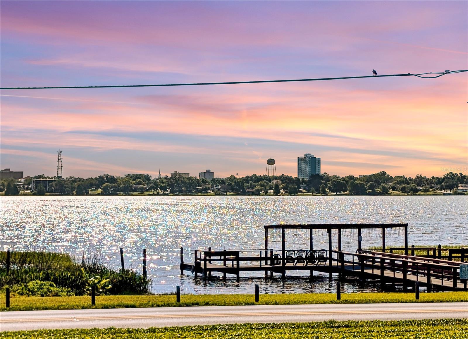 Wake up to views of Lake Howard and enjoy maintenance-free Florida living in the peaceful 55+ community of Imperial Harbours. From the bright Florida Room to the lakeside atmosphere and community amenities, this condominium offers the relaxed lifestyle many buyers move to Florida to find. Conveniently located less than 25 feet from the elevator, this furnished 2nd story condominium features a spacious great room, open dining area, and a pass-through window connecting the kitchen to the main living space. Natural light fills the home, highlighting the laminate and tile flooring throughout. The primary bedroom easily accommodates a king-sized bed with room for additional furniture and offers views of the community pool and cabana area. The en-suite bathroom includes a walk-in closet and walk-in shower. The second bedroom is across the hall from the main bathroom and primary bedroom.  The Florida Room gives you pool and cabana views with sliding glass door separating it from the Great Room. Imperial Harbours amenities include a community pool and cabana, shuffleboard courts, fishing pier on Lake Howard, extra storage space, and a reserved covered parking spot. Lake Howard is part of Winter Haven’s famous Chain of Lakes, and downtown Winter Haven is located just across the lake for convenient access to shopping, dining, entertainment, and local events. Enjoy low-maintenance living, scenic surroundings, and the comfort of a well-established owner-occupied community with no leasing allowed.