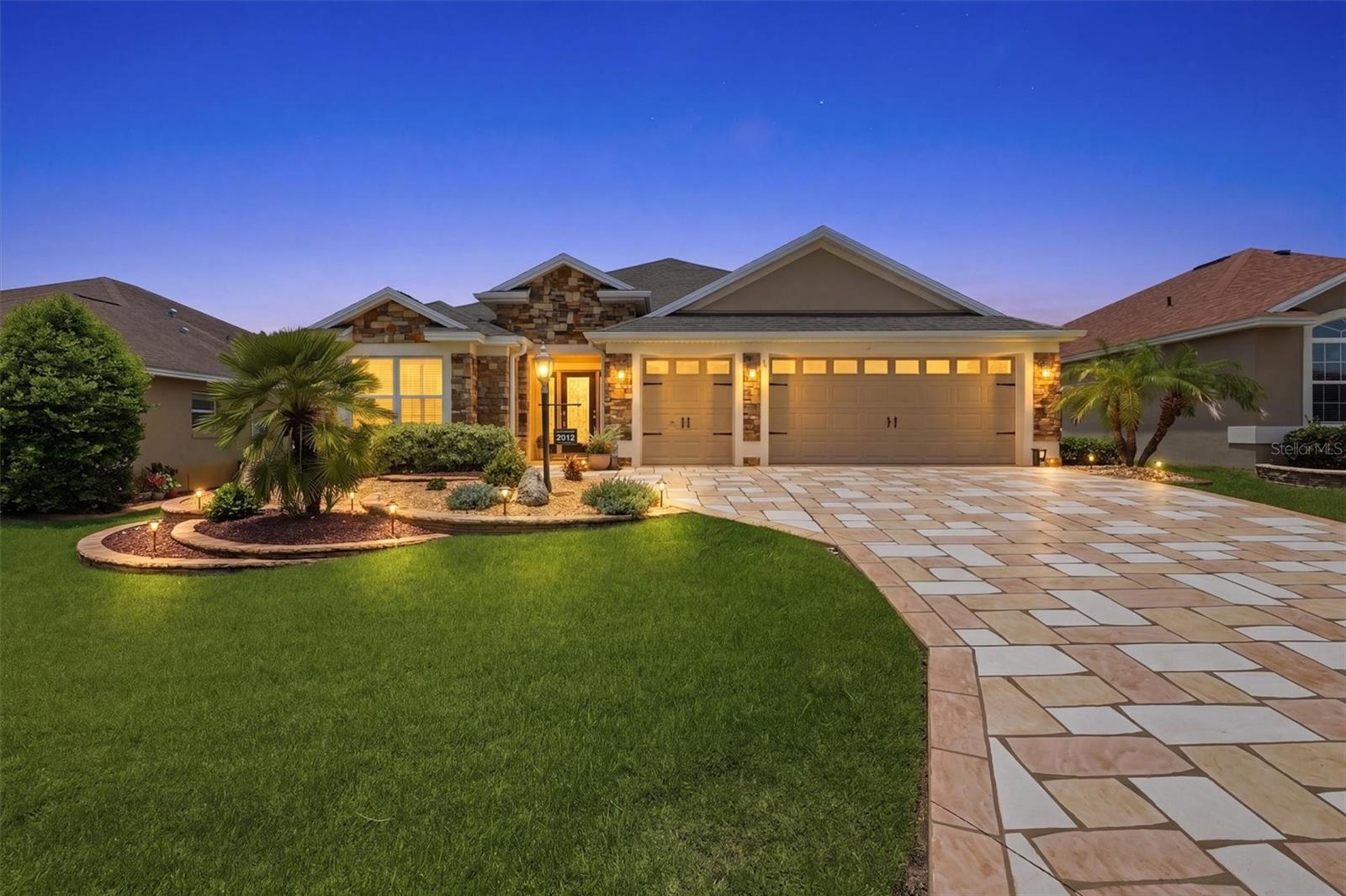 LOCATION! LOCATION! LOCATION! Stunning Designer Iris model in the highly desirable Village of Sanibel offering 3 Bedrooms, 2 Bathrooms, a 2-car Garage plus Golf Cart Garage, and loaded with upgrades! Outstanding curb appeal begins with STACKED STONE, a CUSTOM DESIGNER DRIVEWAY (2023), and mature professional landscaping. Inside, you'll love the OPEN-CONCEPT floor plan featuring CROWN MOLDING throughout, CUSTOM CORNICES over windows and sliding glass door, CERAMIC TILE in the main living areas, and LUXURY VINYL FLOORING in the bedrooms (2018). A large SOLAR TUBE fills the kitchen with natural light. The chef's kitchen boasts GRANITE COUNTERTOPS, TILE BACKSPLASH, STAINLESS STEEL APPLIANCES, DUAL WALL OVENS, a FLAT TOP RANGE, an added PANTRY with pull-out drawers, a breakfast nook, and a formal dining room. The spacious living room opens to the ENCLOSED DOUBLE PANE GLASSED IN LANAI under heat and air, providing valuable additional living space for year-round enjoyment. The split-bedroom floor plan offers privacy with a pocket door separating the guest wing. The FRESHLEY PAINTED PRIMARY SUITE features a TRAY CEILING, CUSTOM WALK IN CLOSET, and ensuite with DUAL VANITIES, ROMAN SHOWER, and PRIVATE WATER CLOSET. The front guest bedroom includes a tray ceiling and custom closet, while the third bedroom offers vaulted ceilings and a custom closet. The GUEST BATHROOM was beautifully REMODELED in 2025 with a TILED SHOWER, GRANITE vanity, updated fixtures, and new toilet. Inside Laundry Room with Wash Tub and Brand New Washer and Dryer.  Additional upgrades include an EPOXY-COATED GARAGE FLOOR, Attic Stairs, Irrigation System, Gutters, STACKED STONE exterior (2017), NEW WATER HEATER (2025), NEW GARAGE REMOTE SYSTEM (2025), NEW WASHER & DRYER (2025), and HVAC DUCTS cleaned and system serviced (July 2026). Low Bond Balance: $13,978.18. Furniture Negotiable. Ideally located just minutes from Captiva Recreation Center, Sanibel Pool, Championship and Executive Golf Courses, Pickleball, Recreation Centers, shopping, dining, and less than five miles from Brownwood Paddock Square. This meticulously maintained, move-in-ready home combines luxury, comfort, and The Villages lifestyle—an exceptional opportunity you won't want to miss! Schedule Private Showing Today!