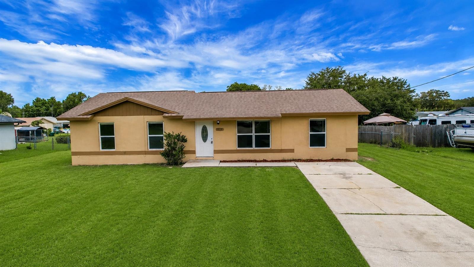Welcome to this cozy 4-bedroom, 1.5-bathroom home in Lady Lake! Step inside to discover fresh interior paint, stylish new light fixtures, and brand-new vinyl flooring throughout. Vaulted ceilings in the main living areas create a bright atmosphere, while the spacious kitchen features stainless steel appliances, a closet pantry, and a dining area perfect for everyday meals or entertaining. The primary bedroom offers plenty of space and includes a convenient en suite half bathroom with some plumbing already in place, providing the potential to add a shower if desired. Both bathrooms have been refreshed with new toilets and sinks, and the full bathroom boasts a recently installed tub/shower. Major updates provide peace of mind, including a roof replaced in 2018, HVAC system installed in 2020, septic and drain field  replaced in 2024, and a brand new water heater. Step outside to enjoy the large, fully fenced backyard, offering plenty of room for entertaining, pets, or simply relaxing. Conveniently located close to shopping, restaurants, and all the amenities of The Villages, this move-in-ready home is one you won't want to miss!