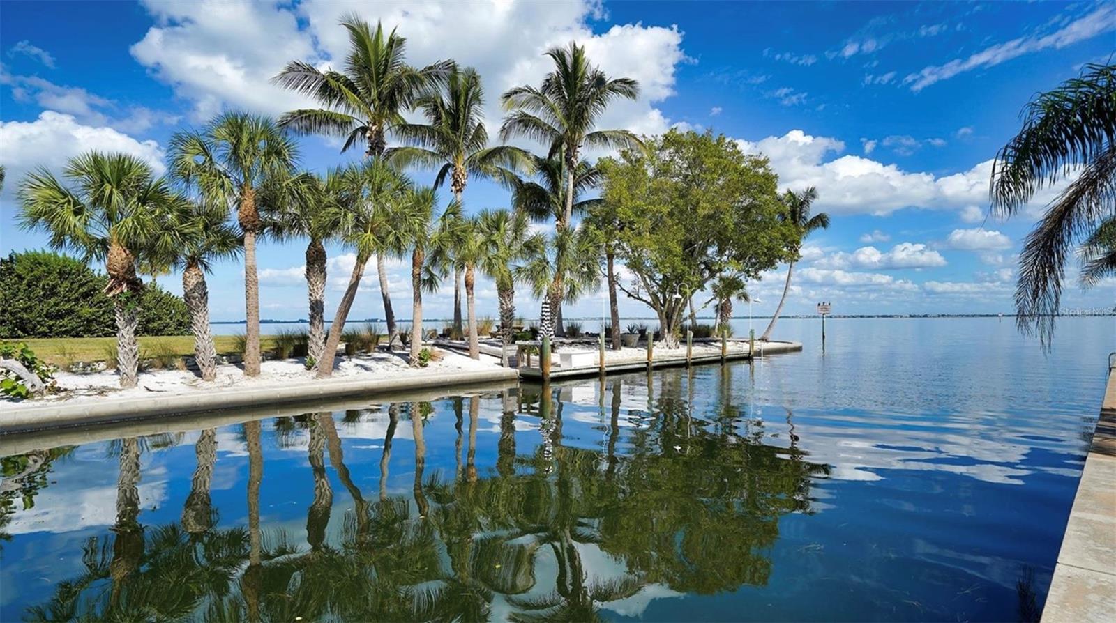 Virtually Staged. PRICE REDUCED! Experience the ultimate Longboat Key lifestyle in this waterfront gem featuring stunning Sarasota Bay and canal views. This spacious residence offers two Bedrooms, two Bathrooms, a versatile Bonus Room (ideal as a 3rd Bedroom, Home Office or private In-Law/Nanny Suite), plus a generous laundry room with newer full-size machines. This villa has been completely and meticulously renovated, with no detail overlooked and no expense spared. Beyond its stunning finishes, this home offers something incredibly valuable: Exceptional Peace of Mind! Major infrastructure updates include new electrical and plumbing systems, new Luxury Vinyl Plank flooring, fresh interior paint, and Hurricane-Impact Windows and Doors throughout. EVEN BETTER...exterior Building Maintenance Repairs and Insurance (including Flood, Hurricane, and Hazard coverage) are all included in the monthly HOA fee, creating a truly low-stress ownership experience. Recent updates include stylishly renovated bathrooms with stone countertops and new vanities, while the spacious new kitchen offers stainless appliances, quartz counters, plus abundant storage and counter space. This home also features a light-filled Florida room opening to a private patio, perfect for outdoor grilling, dining under the stars or watching playful manatees and dolphins in the canal. And for ultimate convenience, everyday living is effortless with the attached covered carport. Beyond your private retreat, Windward Bay offers resort-style amenities across 26 pristine, landscaped bay front acres. Enjoy two heated pools with complimentary lounge seating, saunas, tennis and pickleball courts, a fitness center, shuffleboard, boat slips ($50/month or $55/month with owner-provided lift), kayak/paddle board storage and launch ($45/year), fishing, and three private beach access points. Plus, Zota Beach Resort is just across the street for elegant dining and nightly sunsets. Windward Bay is a proactive, well-managed community that has passed its structural integrity inspection and is certified for another 10 years. Owners may rent up to twice per year with a one-month minimum, offering excellent income potential. Best of all—this rare Longboat Key community is pet-friendly for Owners and Renters! Don’t miss your chance to own a slice of island paradise and enjoy a relaxed, coastal lifestyle surrounded by natural beauty and first-class amenities. Your dream retreat awaits!