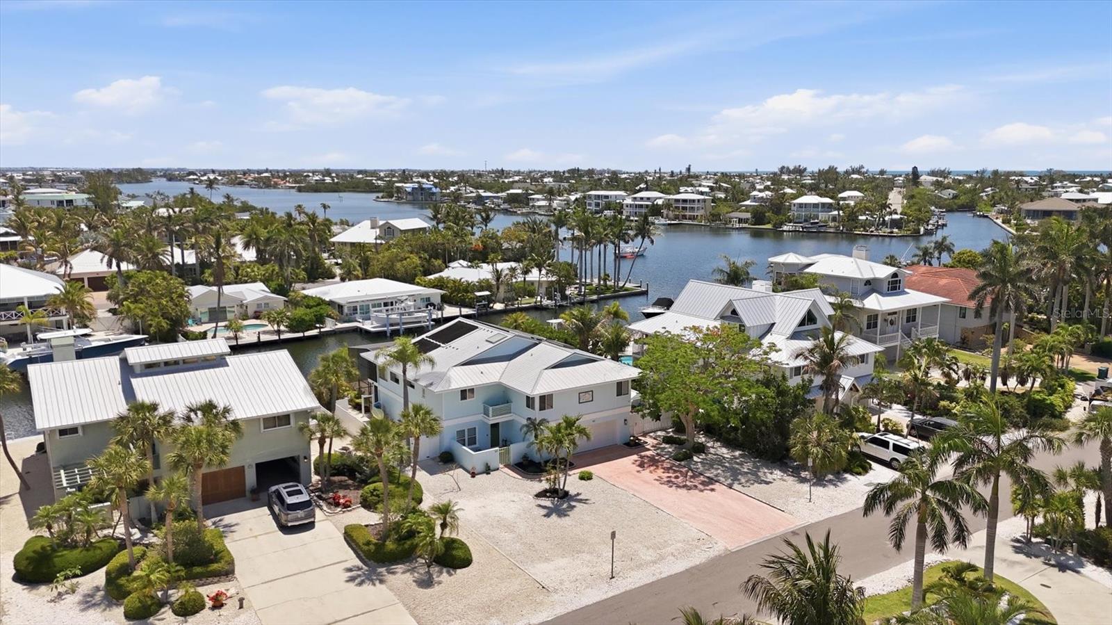 This 4 bed/4 bath waterfront pool home is on a quiet cul de sac, in the city of Anna Maria, with views of Bimini Bay!  Roomy and inviting, with no bridges to the Bay, this boater’s paradise also allows short term rentals!  The spacious floor plan invites you to relax.  Whether you are preparing meals in your open kitchen with freshly painted cabinetry, stainless steel appliances and oversized granite counters, or lounging in your family room with shiplap wall, while enjoying the water views…you will relish island life.  Step outside to your enclosed, Brazilian Teak deck overlooking your large salt water pool, and enjoy the breeze.  Guests will love the large bedrooms…three with en suites!  You will love the low maintenance limestone yard (2022), the seawall being new in 2021, the water & electric at the dock, with your 10,000lb boat lift with new motor (2025),  your custom matching shed, your annually maintained 4 ton AC & updated ducts (2021), your French drain & pump system in driveway (2024), your summer kitchen (2024) and your new garage door (2024).  This home has ample space for everyone, and is just a short walk to the shops and eateries of Pine Avenue.  Come enjoy island life and make this your island oasis!
