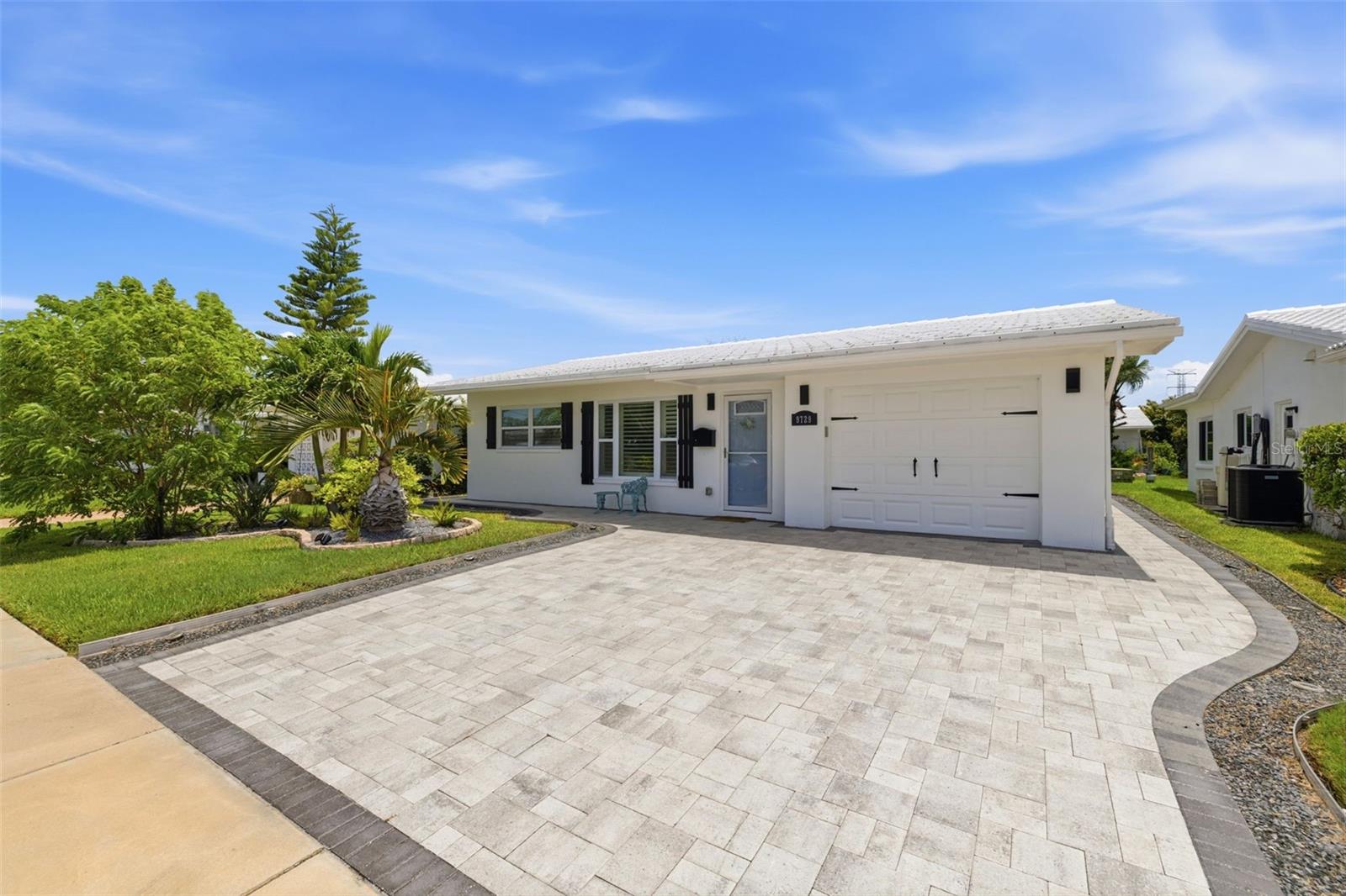 One of the most extensively updated homes in The Mainlands, this beautifully reimagined 2-bedroom, 1-bath residence with a dedicated den/office blends quality craftsmanship, thoughtful design, and easy Florida living in one of Pinellas County’s most desirable 55+ communities.

From the moment you arrive, you’ll appreciate the inviting curb appeal featuring an oversized paver driveway, updated exterior shutters (2025), tropical landscaping, and a welcoming entrance. Inside, the home was refreshed with designer-selected interior paint and finishes in 2025, creating a light, bright, and truly move-in-ready space.

The custom kitchen is the heart of the home, showcasing soft-close cabinetry, quartz countertops, stainless steel appliances, a built-in wall oven, cooktop, stylish backsplash, reverse osmosis water filtration, abundant storage, and a spacious butler’s pantry with additional custom cabinetry. Built-in cabinetry in the dining area adds both beauty and functionality.

The completely remodeled bathroom (2026) creates a fresh, spa-inspired retreat, while both bedrooms feature new carpet (2025) and custom closet systems with built-in organization. Plantation shutters throughout, crown molding, updated lighting, new interior doors, and numerous custom finishes enhance every room.

A versatile den provides the perfect space for a home office, hobby room, library, or additional sitting area.

Step outside to your own private retreat where expansive paver patios extend around both sides of the home, creating multiple spaces for entertaining, grilling, or simply enjoying Florida’s beautiful weather. Mature privacy landscaping surrounds the outdoor living areas, while the enclosed patio provides a comfortable space to enjoy year-round.

Additional improvements include a well-maintained HVAC system inspected in 2025 with no issues reported, a water heater with coverage, and garage storage. The roof is scheduled to be replaced and is covered by the HOA, providing valuable peace of mind.

Located in The Mainlands Unit 4, one of the community’s most desirable sections, residents enjoy the added benefit of underground utilities, helping create a cleaner streetscape while reducing the likelihood of storm-related power interruptions compared to overhead utility lines.

The monthly HOA fee covers nearly everything except electricity, including water, sewer, trash, cable service, plus streaming services, lawn maintenance, and roof replacement, making homeownership simple and convenient. Residents also enjoy a vibrant 55+ lifestyle with a community clubhouse, heated pool, shuffleboard, social activities, and an adjacent public golf course, all just moments from the home.

With extensive updates, quality finishes, and an exceptional location near the clubhouse, this move-in-ready residence is a rare opportunity to enjoy the very best of The Mainlands lifestyle.