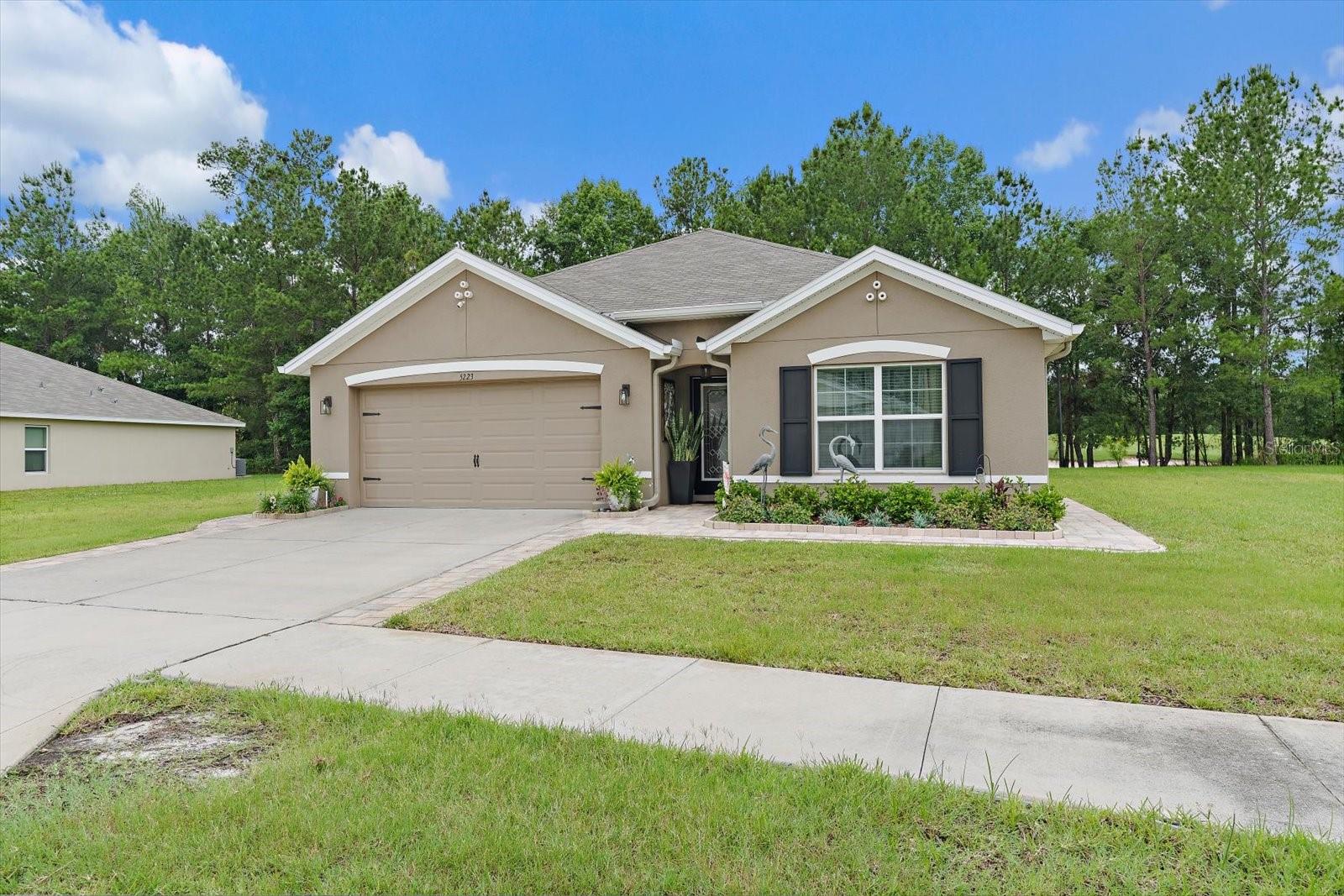 Welcome to this beautifully maintained 4 bedroom, 2 bath home nestled on a spacious cul-de-sac lot in Brooksville's desirable golf course community. Built in 2022, this move in ready residence offers the perfect blend of modern design, comfort, and functionality with no carpet. The Seller has added crown molding in the entire house, a sink in the garage, and a beautiful kitchen backsplash. Step inside to discover an open concept floor plan featuring a bright and airy living area that seamlessly flows into the dining space and well appointed kitchen. The kitchen is designed for both everyday living and entertaining, complete with ample cabinetry, generous counter space, a large island overlooking the main living areas, a spacious pantry, and a coffee bar area. The private owner's suite provides a relaxing retreat with a spacious bedroom, walk-in closet, and ensuite bath. Three additional bedrooms add flexibility for family, guests, or a home office. Enjoy Florida living year round from the covered lanai overlooking the expansive backyard, providing plenty of room for outdoor entertaining, gardening, or future enhancements. The Seller has spared no expense by adding beautiful pavers in the back and paver pathways to the front of the house, added a BBQ grilling area, and has manicured underneath the trees. The oversized lot adds privacy and space rarely found in newer construction homes. Conveniently located near shopping, dining, medical facilities, and major highways, this home combines peaceful community living with easy access to Brooksville and Tampa Bay. Don't miss this opportunity to own a newer construction home with modern finishes, a desirable layout, and an exceptional location. Schedule your private showing today!