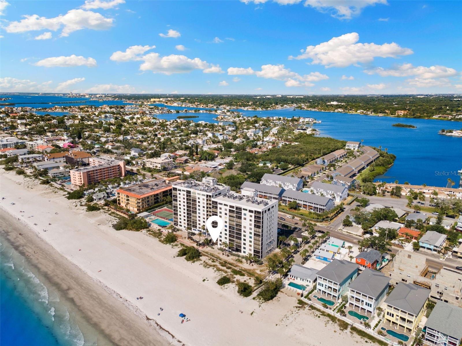 Rare ground-floor, end-unit on the sands of Indian Rocks Beach! With your private lanai mere short distance from the white sugar sands of one of America’s beast beaches, this home’s view will stop you in your tracks. In the beloved Reflections community, you have access to tennis/pickleball courts, a pool, spa, sauna and reservable lobby area. You have two bedrooms, two baths and 1,275 square feet of living space right on the Gulf. As you approach the building, you will park in your dedicated carport parking space. The tiled staircase will welcome you into the secure lobby. From here, you have quick access to your unit. No need to wait for the elevator because your home is the first door on the first floor- making getting home a breeze for you and your guests. Entering the home, you will immediately be swept away by the view straight to the Gulf. To your right is the kitchen with recently spruced features, including a tile backsplash, quartz countertops, newer appliances and wood-faced cabinets. There is a quaint breakfast bar in the kitchen where you can overlook the Gulf views, and beyond the kitchen there is the lovely dining area which flows seamlessly into the spacious living room. The flooring in the home is all tile and new luxury vinyl plank. To the left of the entryway is the guest bedroom and bath. The bedroom is spacious with two full-size beds and has a guest closet and locked owner’s closet. The guest bath has a bathtub/shower combination, quartzite countertop vanity and a spacious linen closet just outside the bath door. The primary bedroom has an incredible view of the beach from the large window as well as sliding glass doors to access your private, screened-in lanai. The primary en-suite bath has dual vanities with quartzite countertops, a walk in-closet, and a pocket-door entry into the separated walk-in shower and water closet. Just outside the entrance to the spacious primary bedroom is a dedicated laundry room with newer stackable washer and dryer. This is also where you’ll find the updated 2020 electrical panel and 2020 Trane HV/AC unit. All windows in the home have tasteful plantation shutters. The sliding glass doors have been upgraded to be hurricane impact rated. Plus, you have electric hurricane shutters to cover the back windows and lanai. Speaking of the lanai, it’s just a few steps down to a paved patio right on the sand. To the right, you are near to the building’s private beach access. Around the corner is the community pool, hot tub, and pickleball/tennis courts. There is a two-week rental minimum in this complex and ground-floor units are desired by guests and owners alike. All special assessments have been paid, and work is estimated to be completed by end of May! The furniture in the unit is optional in the purchase, making the home turnkey. Indian Rocks Beach boasts 26 public beach accesses and some of the best beaches in the country. You are across the street from Indian Rocks Nature Preserve on the intracoastal, blocks away from local eateries such as Guppy’s, Crabby Bill’s and The Grove Coffee Shop. You’re 25 minutes to St. Pete-Clearwater Airport, 40 to Tampa International Airport, 14 to Clearwater Beach, 35 to downtown St. Petersburg and seconds from your toes hitting the white sand of the Gulf Coast. This property is a star with a ground-floor, end unit with carport and shared storage closet. Schedule a private showing. Floor plan and video available.