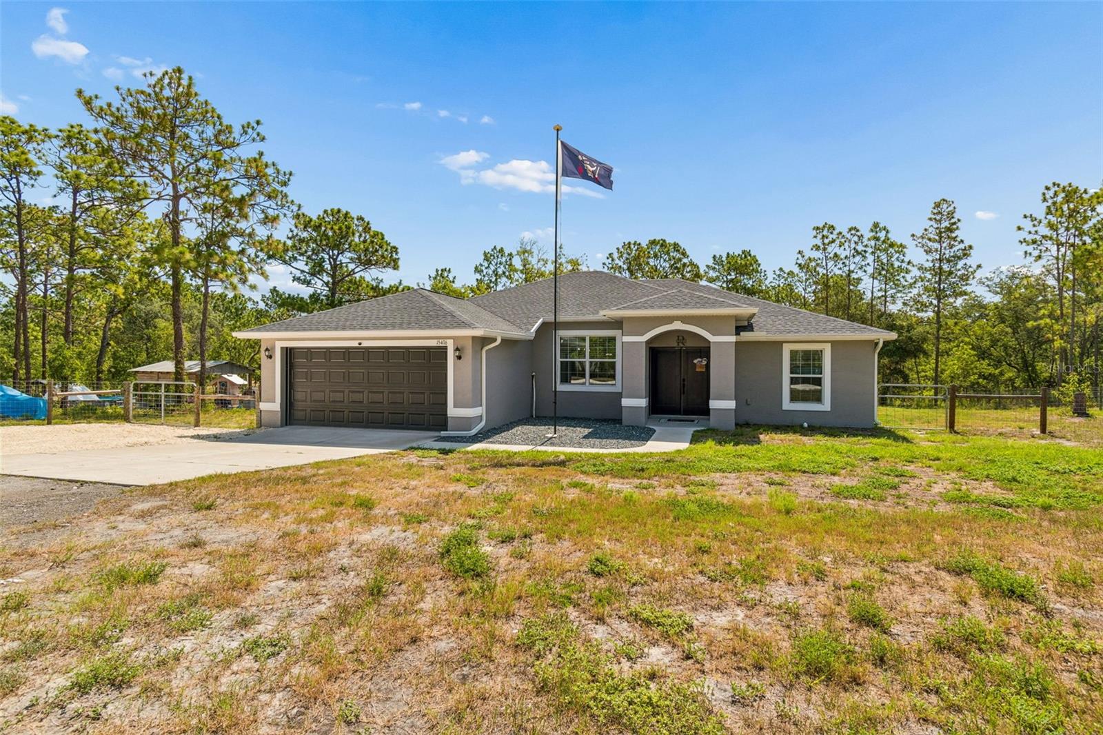 WELCOME to your DREAM HOME in Royal Highlands! This STUNNING 2023-built, 3-bedroom, 2-bathroom BLOCK CONSTRUCTION HOME delivers 1,698 heated square feet of THOUGHTFULLY DESIGNED living space on a SPRAWLING 1.1-acre lot with AGRICULTURE REZONING POTENTIAL, offering the FREEDOM and FLEXIBILITY of true country living without sacrificing modern comfort. Inside, you are greeted by a BRIGHT, OPEN-CONCEPT floor plan featuring SOARING ceilings, modern industrial pendant lighting, recessed lighting, and gorgeous WOOD-LOOK tile flooring throughout the main living areas. The CHEF'S KITCHEN is a true showstopper with crisp WHITE RAISED-PANEL SHAKER CABINETS, gleaming GRANITE COUNTERTOPS, a LARGE ISLAND with breakfast bar seating for four, a FARMHOUSE APRON SINK, and STAINLESS STEEL APPLIANCES including a French door refrigerator with ice maker, built-in microwave, and electric range. The SPACIOUS PRIMARY SUITE features a TRAY CEILING, ceiling fan, and a SPA-LIKE en-suite bathroom with a DOUBLE GRANITE VANITY and a WALK-IN GLASS SHOWER finished with FLOOR-TO-CEILING TILE and a RAIN SHOWER HEAD. Two additional GENEROUSLY SIZED bedrooms, one with a WALK-IN Closet, each have ceiling fans and share a well-appointed guest bath with granite counters. Built for MAXIMUM COMFORT and ENERGY EFFICIENCY, this home was constructed with COREFILL FOAM INSULATION injected directly into the block walls, a whole-home WATER SOFTENER, and a GENERATOR SWITCH AND PLUG (generator not included) so you are ALWAYS PREPARED. An INTERIOR LAUNDRY ROOM adds everyday convenience, and the 2-car garage provides ample storage. Step outside and experience the ULTIMATE OUTDOOR LIFESTYLE with a SCREENED BACK PORCH with ceiling fan perfect for relaxing, EXTENDED SLAB PATIO, a CUSTOM PAVILION featuring a ceiling fan, paver patio, a dedicated SMOKE HOUSE for smoking meats, and a wood-fired OUTDOOR PIZZA OVEN that makes every gathering UNFORGETTABLE. Beat the Florida heat in the ABOVE GROUND POOL, gather around the FIRE AREA on cool evenings, and take advantage of the CHICKEN COOP with fenced run (chickens not included) and additional metal storage shed, making this property TRULY TURN-KEY for the hobby farmer or outdoor enthusiast. PERFECTLY LOCATED for everyday convenience, this home sits just minutes from the ICONIC Weeki Wachee Springs State Park, where you can enjoy world-famous mermaid shows, kayaking, and natural spring recreation right in your own backyard. You are also a short drive from US-19/Cortez Boulevard and the SUNCOAST PARKWAY (SR-589) for quick access to Tampa and beyond, with Publix, Walmart Supercenter, and Winn-Dixie nearby for all your grocery needs, and HCA Florida Oak Hill Hospital and Bayfront Health Spring Hill close at hand for healthcare. This is a RARE OPPORTUNITY to own a LIKE-NEW, MOVE-IN READY home with the SPACE, FEATURES, and LIFESTYLE you have been searching for.