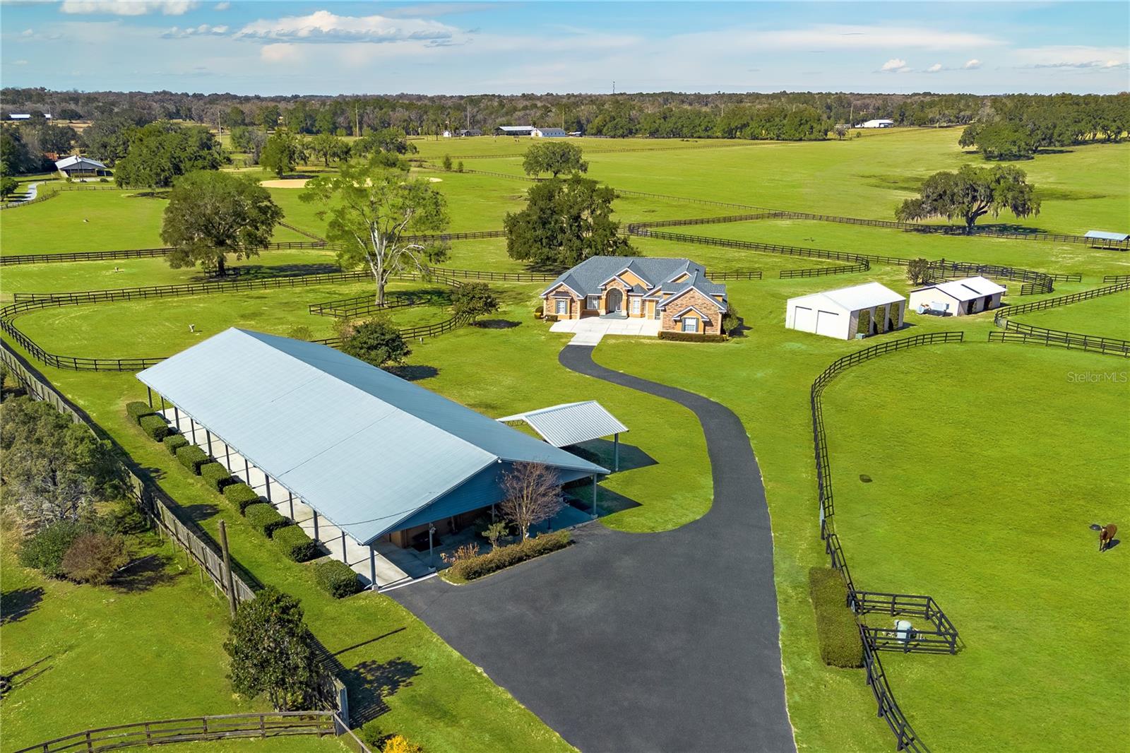 One or more photo(s) has been virtually staged. One or more photo(s) has been virtually staged. Nestled amongst established horse farms in the heart of Marion County’s Farmland Preservation Area, this exceptional estate offers a rare blend of privacy, lifestyle, and versatility. Set on nearly 20 gated and fenced acres, the property provides a beautiful backdrop of open pasture, mature trees, and peaceful countryside views—ideal for those seeking a refined country retreat with room to expand.At the center of the property is a custom 4-bedroom, 4-bath home offering over 3,100 square feet of thoughtfully designed living space. Light-filled and inviting, the home features a split-bedroom floor plan, high ceilings, and a seamless flow between living areas. The kitchen is well-equipped with stainless steel appliances, ample cabinetry, center island, pantry storage, and a breakfast nook with mitered windows overlooking the pool. The adjoining family room, anchored by a gas fireplace, creates a warm and comfortable space for gathering and entertaining.The primary suite is a private retreat with bay windows, dual walk-in closets, and a spacious en-suite featuring a walk-in shower, garden tub, dual vanities, and heated tile floors. Additional highlights include formal living and dining areas, an oversized attached garage, and a full laundry room with built-in cabinetry and sink. A second-floor suite with full bath and walk-in closet offers flexible use for guests, in-laws, or a private office. Outdoor living is equally inviting, with a large covered patio overlooking a sparkling in-ground pool and expansive deck—perfect for enjoying Florida’s year-round sunshine.Equestrian amenities enhance the property’s appeal without overwhelming its estate feel. A 15-stall shed-row barn includes a tack room, feed room, covered  wash rack, and office/barn apartment, while seven paddocks feature 3-board fencing, mature shade, and automatic waterers. Additional outbuildings provide ample storage for equipment, trailers, or recreational vehicles, and an RV hookup adds further flexibility.With partial B2 zoning, the property also offers unique potential for a home-based or agriculture-related business, providing an added layer of opportunity  for those looking to combine lifestyle and purpose. Conveniently located just minutes from Majestic Oaks, Sweet Dixie South, HITS, and the World Equestrian Center, this property delivers the best of Ocala’s horse country—offering space, comfort, and future potential in one exceptional setting.