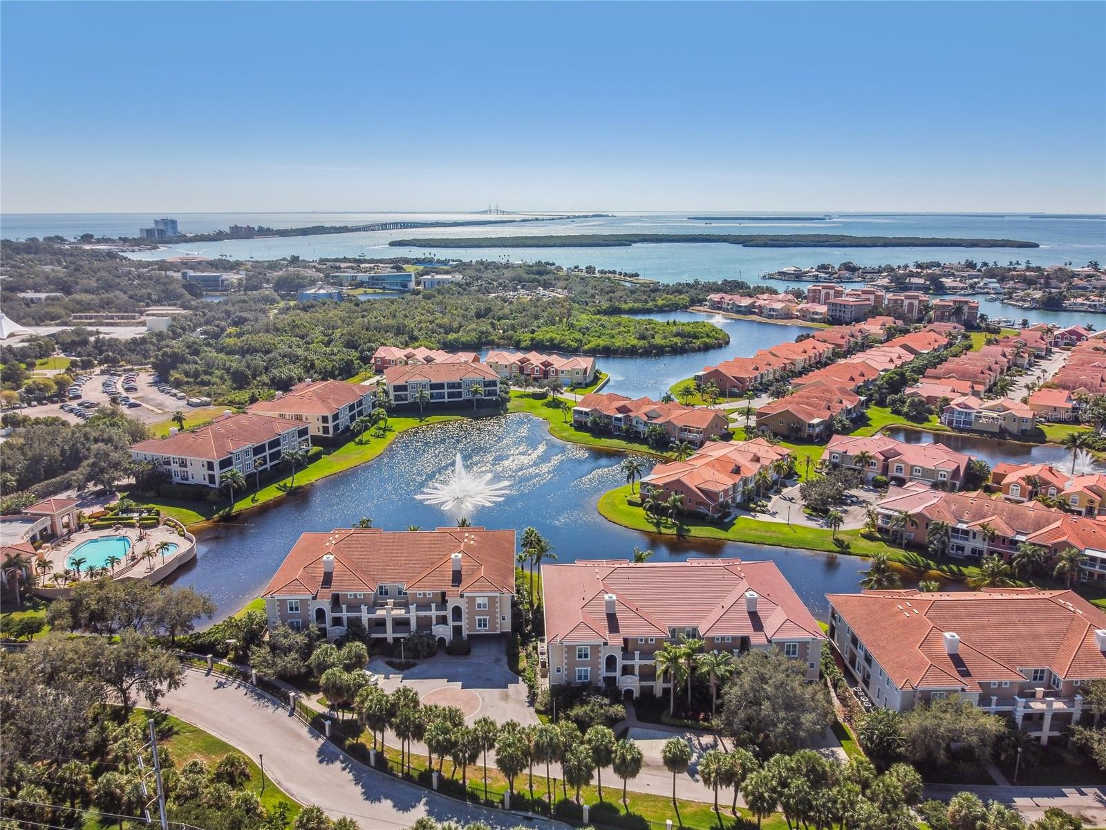 Contemporary Mediterranean-inspired end-unit townhome in gated Marina Bay with lake views, vaulted ceilings and an open, single-level living floor plan served by a private elevator. This 3-bedroom, 2.5-bath residence offers 2,574 square feet with 10-foot ceilings, stainless steel appliances, Cambria countertops, natural gas cooking, oversized walk-in pantry, covered lanai, integrated surround sound, remote-control blinds, built-in bar with wine fridge, custom closets, and a 22kW Generac natural gas generator. The private owner’s suite includes dual vanities, walk-in shower and separate soaking tub. Nearly 2,500 square feet of garage space provides room for multiple vehicles, storage, recreation equipment or workshop use. Marina Bay offers gated waterfront living, pools, spas, fitness center, clubhouse, fishing pier, Pinellas Trail access, tropical landscaping and convenient access to downtown St. Petersburg, Gulf beaches and Tampa International Airport.