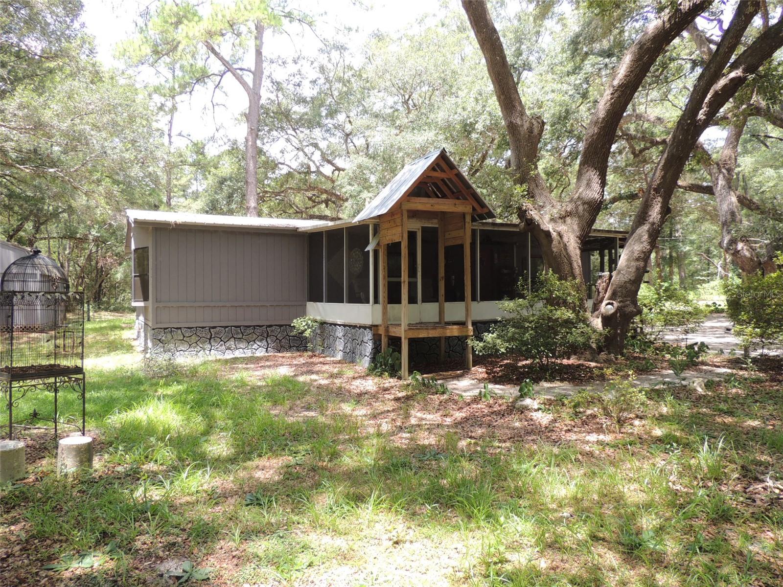 MORE THAN JUST A HOME - THIS IS A LIFESTYLE OPPORTUNITY. Almost 9 Private Acres | 2 Bed, 2 Bath | Workshop, RV Hookups & Room to Breathe. This versatile estate is ideal for anyone seeking a secluded country homestead, hobby farm, recreational retreat, or simply room to live without subdivision restrictions. The light-filled 2 bedroom, 2 bathroom home features updated flooring, a cozy wood-burning fireplace, and a highly flexible private owner's suite—perfect for multi-generational living, guests, or a remote home office. Move-in ready with modern peace of mind, the home boasts comprehensive recent updates including updated plumbing, a brand-new electrical panel, a newly leveled foundation, and engineer-certified tie-downs.
Outside, the acreage is a dream for hobbyists, retirees, and those relocating for a peaceful rural lifestyle. A spacious, detached workshop offers the perfect footprint for your hobbies, while multiple storage buildings and dedicated RV parking easily accommodate all your toys and equipment. The expansive, unrestricted land is ready for livestock, gardens, or private trail riding, all complemented by an above-ground pool for easy outdoor relaxation. Enjoy ultimate privacy and absolute freedom to create your own country paradise without sacrificing quick, convenient access to Williston, Ocala, and Gainesville. Schedule your private tour today to experience total property freedom.