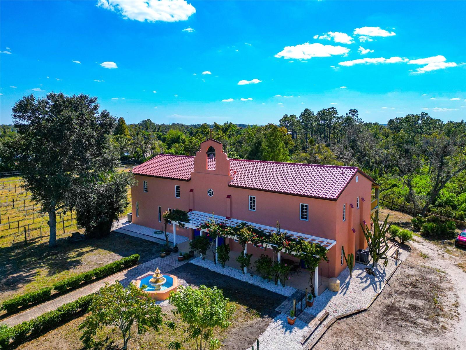*** MOTIVATED SELLER - BRING ALL OFFERS. AVAILABLE FOR A QUICK CLOSE. 20 Acres Non-Deed Restricted, Vineyard, Brand New Roof, Recent Appraisal $3.9m, 4920 Sq ft (total 7500 sq ft), 7 BDs, 5.5 Baths, 2 Kitchens, Horse Barn, Separate Entrances, New Flooring, Interior & Exterior Painting, Massive upgrades all 2025. behind private gates and set on just under 20 ACRES of NON-DEED RESTRICTED LAND, this expansive Mission-style estate offers exceptional privacy and a multitude of possibilities. 4,920 square feet, Total 7500 Sq Ft, 7 BEDROOMS with the flexibility to convert to 9, along with 5.5 BATHS, 2 KITCHENS, 2 living rooms, 2 offices, den, huge studio and a formal Din rm. Originally an award-winning vineyard, the HOME HAS DOUBLED IN SIZE under the current ownership, presenting ideal potential for MULTI-GENERATIONAL living, EQUESTRIAN use, retreat property, business use or further custom development. *** 2025, over $300,000 in IMPROVEMENTS WERE COMPLETED, including a BRAND-NEW TILE ROOF (July 2025), professional EXTERIOR & INTERIOR PAINTING, NEW ENGINEERED HARDWOOD FLOORING ENTIRE FIRST FLOOR, and the addition of two new A/C split systems to detached workspaces. All A/C ductwork w/ vent covers replaced on the first floor, all three A/C units were serviced and deep cleaned, and two UV light purification systems were installed. A NEW WATER FILTRATION SYSTEM & updated attic insulation further enhances efficiency and comfort. This house was constructed with 12' block w/ rebar reinforced throughout.  Windows were converted to Hurricane Impact in 2008 & in 2012 with the new addition. Elevation is at 55' and the house & barn have never flooded.  This homes design with MULTIPLE SEPERATE ENTRANCES; 2 KITCHENS and separate living areas can easily be used as a MULTI-GENERATIONAL dwelling. The main level showcases a large primary BD with NEW ENGINEERED HARDWOOD FLOORING, an oversized walk-in closet, and French doors overlooking the surrounding vineyard landscape. The ensuite bathroom features a custom marble double vanity, soaking tub and a walk-in shower with multiple jets. Also located on the main floor are the living room, formal dining room, Den, and an additional ensuite bedroom. The chef’s kitchen offers commercial-grade GE Monogram stainless steel appliances, 42-inch solid wood cabinetry, extensive granite countertop space and a prep island with secondary sink; travertine flooring extends into the adjacent laundry and pantry area. The second level includes a kitchen and family room with vaulted ceilings, refinished wood floors, five bedrooms, three full bathrooms and three bonus rooms. Accessed by a separate rear staircase, this area offers an ideal opportunity to create private guest quarters or increase the total bedroom count to nine with minimal renovation. Two detached rooms, 36.8' x 23' total sq ft (& total both rms) and fully under air, have been completely refurbished to accommodate studio space, workshops or conversion to additional living or entertainment areas. On-site barn is well suited for equestrian use. A SPRING-FED STREAM runs through the center of the acreage. Directly across from LAKE MANATEE STATE PARK, which offers additional trails for horse riding. This remarkable estate combines non-deed restricted acreage, privacy and extensive recent renovation with true opportunity for customization and highest and best use.  Minutes from LWR, Dining, Shopping & Great Nature Parks. Recent Appraisal performed valued at $3.9M