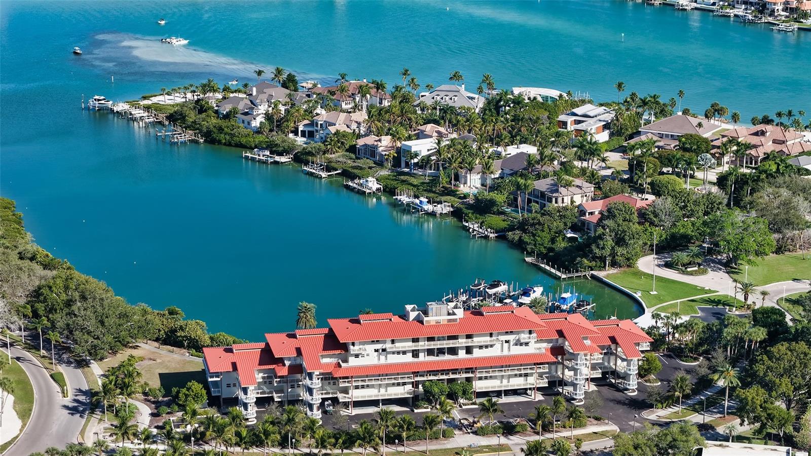 Tropical elegance awaits in this thoughtfully updated Junior Suite, which pairs tranquil lagoon views with strong rental potential through the established hotel program. Impact-rated sliding glass doors lead to a private, open terrace with a glass railing, allowing the lush, tropical setting to remain the focal point while inviting the outdoors in. Inside, the residence feels airy and welcoming thanks to 10’ ceilings and a carefully curated blend of textures and finishes. Faux wood tile floors run throughout, complemented by crown molding and warm wall accents with shiplap detailing that add depth and character without overwhelming the space. The dining nook is intimate and inviting, enhanced by a rich wood feature wall that creates a relaxed, comfortable atmosphere for casual meals or evening unwinding. The kitchen is both stylish and efficient, featuring stone countertops, crisp white cabinetry with glass-panel details, stainless steel appliances and a patterned tile backsplash that brings subtle visual interest. The bathroom continues the elevated feel with a spa-inspired design, offering dual vanities, a walk-in glass shower with detailed tilework and natural textures that create a calming retreat after a day in the sun. Offered fully furnished and seamlessly integrated into the hotel rental program, this residence allows owners to enjoy flexibility while benefiting from resort-level operations. Ownership includes access to the exclusive 410-acre Longboat Key Club, with five acclaimed dining venues, 45 holes of championship golf, the award-winning Tennis Gardens, spa and fitness facilities, a private white-sand beach with attendant service, and a full-service marina. Recent property-wide updates to guest rooms, pool areas, dining spaces, and services further enhance the experience at this AAA Four-Diamond destination.