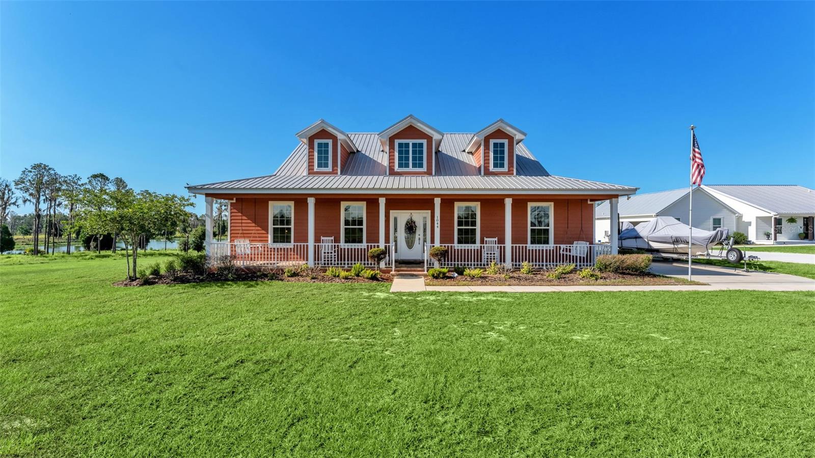 Welcome To This Little Piece Of Heaven! This Exquisite LAKEFRONT Beauty Is Elegant Country Living At Its Finest! This hidden gem is a 3-bedroom 2 bath home built by Jasper Custom Homes and nestled on a picturesque 2.39 acres with over 100 feet of private lake frontage. This craftsman-style home offers an unparalleled combination of elegance, tranquility and breathtaking views. As soon as you arrive you will immediately notice the charming full-length front porch where you can sip your coffee and soak in the morning sun. As you step inside, you'll be captivated by the gorgeous details and the rich laminate flooring and cozy electric fireplace which creates a warm and inviting atmosphere. The expansive living areas flow seamlessly to the outdoors, where a huge screened-in lanai offers the perfect space for relaxation and entertainment. The gourmet kitchen, which is a chef's dream features elegant granite countertops, stainless steel appliances, gorgeous backsplash, built in pot filler, spacious walk-in pantry and a wine/coffee bar. The Master Suite is a spacious retreat with tray ceilings and an electric fireplace to decompress from your day. Relax in your spa inspired bathroom, which boasts multiple walk-in closets, his and her vanities, a walk-in shower with dual showerheads and a soaking tub with breathtaking views! Other features include Remote-Control Window Shades, Multi-Slide Doors, Barn Door in Master Bedroom, Crown Molding, Metal Roof, and an Owned Water Softener. Additionally, the property includes a spacious shed that could be a workshop or storage for all your hobby needs. Outdoor enthusiasts will appreciate the expansive yard, which offers plenty of space for gardening, recreation, and entertaining. The Majestic trees gracefully canopy the landscape, casting a soothing shade along the lake shore. The exquisite and well-maintained landscaping embodies the essence of rustic, Florida design, with its full and lush beauty. Whether you're fishing in the tranquil lake or relaxing on a hammock on a beautiful day, this hidden gem offers a harmonious blend of relaxation and nature. If you're hosting a gathering or enjoying a quiet evening by the water, this home has it all. Don't miss the chance to own this extraordinary lakefront property.  Schedule your private showing today and experience the perfect blend of modern comfort and peaceful country living.