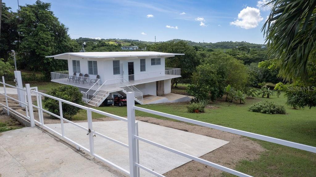 Casa Shaman is a turn-key newly remodeled two-story home is situated in the quiet and serene neighborhood of Bastimento.  The surrounding grounds are a nature lovers dream with with numerous fruit trees and local spices (Corazon, Mango, jobo, achiote, oregano brujo, cereza, and many more).  With almost one acre of land, the property also provides ample space for outdoor living and future expansion, the addition of a pool, garage, and/or guest house.

The upper level of the structure is the heart of the home, with an open-concept living area with kitchen, dining, and living spaces seamlessly flowing into each other. The wraparound balcony offers sweeping views of the lush surroundings. This level also includes two spacious bedrooms and one full bath. 

The first level has an large unfinished versatile studio that includes a full bathroom and kitchenette.  The space can be finished as a one bed, one bath loft for guests or as an income producing rental. The generous space is large enough to keep a storage area, ideal for all your gear or as a potential workspace.

With a gated, paved entry, this home offers peaceful, quiet living at just a short distance of all your needs. The bustling town center is a quick 5-minute drive away, offering easy access to shops, restaurants, and amenities, and Bastimento Beach is only a 15 minute walk from the property.