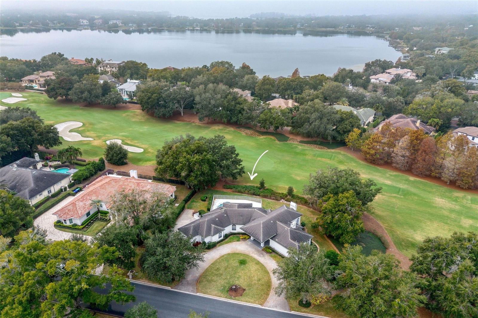 Situated on the 6th fairway along the course of Isleworth Golf & Country Club, this updated golf front sparkles with new porcelain tile throughout and modern chandeliers. This single-story residence was renovated in 2020 featuring a new tile roof, fresh paint inside and out, all bathrooms updated and a fully renovated kitchen. Spanning over 3,300 square feet, the 4-bedroom, 4.5-bath is nestled in the heart of Windermere, Florida. 

The foyer with groin ceiling is light and bright as natural light floods into the home from the glass entryway. Arched details abound in the entrance and this staple in Mediterranean design is carried throughout the estate. Two steps down into the sunken formal living room, the gas fireplace is the centerpiece featuring an artistic stone slab above the hearth and framed by wall-to-wall stacked stone. Completing the space are four large arched windows, two arched doors providing access to the back garden and a built-in dry bar. Situated between the family room and formal living room, and serviced by the nearby kitchen, the formal dining room offers the same illumination of natural sunlight from two large arched windows. 

The kitchen features new KitchenAid stainless steel appliances, a NXR Pro gas range and built-in 40 bottle Euro Cave wine fridge. The custom cabinetry provides ample storage and tastefully pairs in a dark grey-brown tone with the white tile backsplash, multi-tonal grey to white tile range hood and marble counters with soft neutral veins. The custom cabinetry continues seamlessly into the family room with built-in entertainment center. 

Down the hall from the kitchen and family room are the guest rooms. The first features an ensuite bathroom and the other two bedrooms are serviced by the hall bath with dual sinks. The hall bath also provides access to the patio and serves as the pool bath. 

Situated on the opposite end of the home, we find the primary suite, powder bath off the foyer and a flex room. The primary is airy and bright with arched windows, stacked stone fireplace and a dazzling chandelier. The suite features two separate bathrooms – one with walk-in shower and the second with free-standing soaking tub. The walk-in closet offers a warm cedar wood ceiling and custom built-ins. The flex room proposes many uses whether it be an office, nursery, gym, den or library. 

This stunning property offers a seamless blend of indoor-outdoor living boasting a covered patio with fireplace, open-air pool with spa and views of the fairway. Rounding out the estate is a welcoming circular driveway that extends to the rear motor court with two-car garage plus golf cart parking. Whether hosting or unwinding, this home elevates every moment.