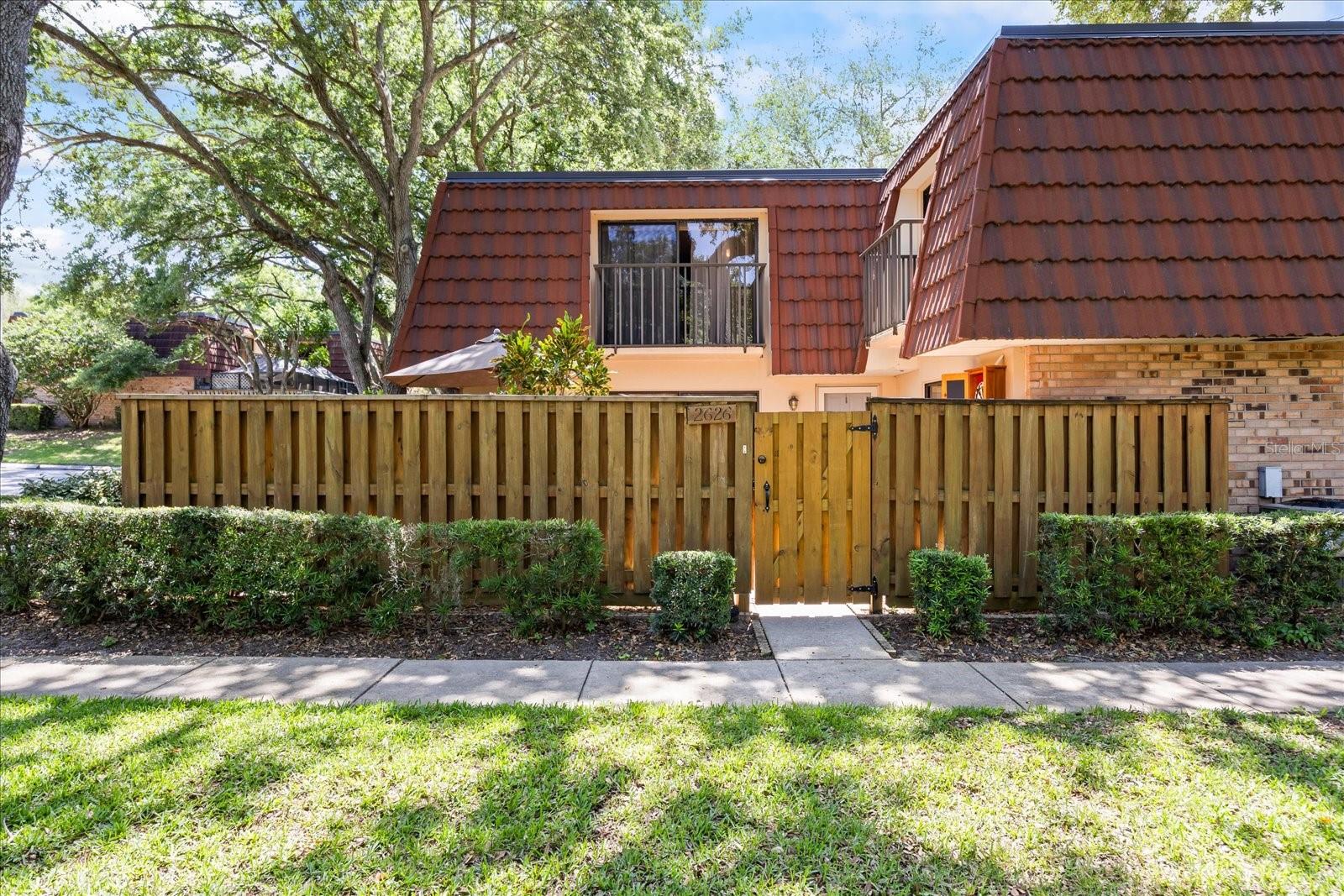 Virtually Staged. Escape to the quiet privacy and natural serenity of Palm Harbor’s sought-after Wedge Wood community. Hidden away beneath a canopy of majestic oak trees, this beautifully maintained, two-level residence delivers the distinct space, privacy, and look of single-family living—without the cost and maintenance. Featuring a sprawling, nearly 500-square-foot private enclosed courtyard and over 1,300 square feet of thoughtfully upgraded living space, this home feels remarkably independent. Inside, the attractive kitchen boasts several upgrades, including hardwood cabinetry, quartzite countertops, a breakfast bar, and abundant storage. Adjacent to the kitchen is the half bath/laundry room, complemented by a space-saving stacked washer and dryer. The sunlit interior is modern and bright, showcasing smooth ceilings with no popcorn, large windows, and private balconies overlooking the lush landscape. Upstairs, the primary suite serves as a peaceful retreat, complete with a walk-in closet, private balcony, and an ensuite bath with stunning stone counters and glass shower. Storage is a bonus throughout this unit, with cleverly integrated closets and spaces designed to make everyday organization effortless. Positioned in a prime location within the neighborhood, this unit sits less than 100 feet from the community pool, clubhouse, and playground. Wedge Wood offers a true resort-style lifestyle, featuring tennis, racquetball, and basketball courts. Centrally located just off US Hwy 19 and Tampa Rd, you are minutes from shopping, dining, Gulf beaches, the vibrant downtowns of Palm Harbor, Dunedin, and Tarpon Springs, and near access points for major hubs like Tampa and St. Pete. A truly exciting opportunity in an outstanding community, not to be missed!