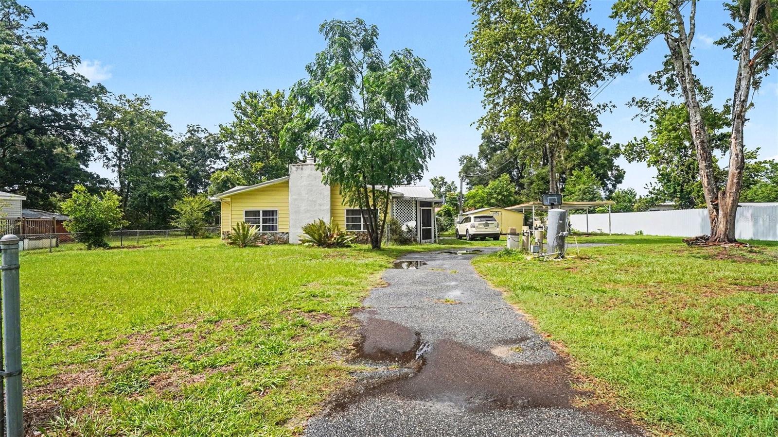 Charming 3-bed, 2-bath home on .35-acre lot in Breezewood Estates. Recent updates include newer roof (~4 years), HVAC (~3 years), and recently updated bathrooms with pergo flooring throughout. Detached carport with storage shed. Well water with whole-home filtration system, septic, electric. No HOA. Mature trees and chain-link fencing across the back. Bonus room off living area with plumbing in place could be storage or 3rd bath build-out. Easy access to FL Turnpike and The Villages. Sold AS-IS in place — bring offers.