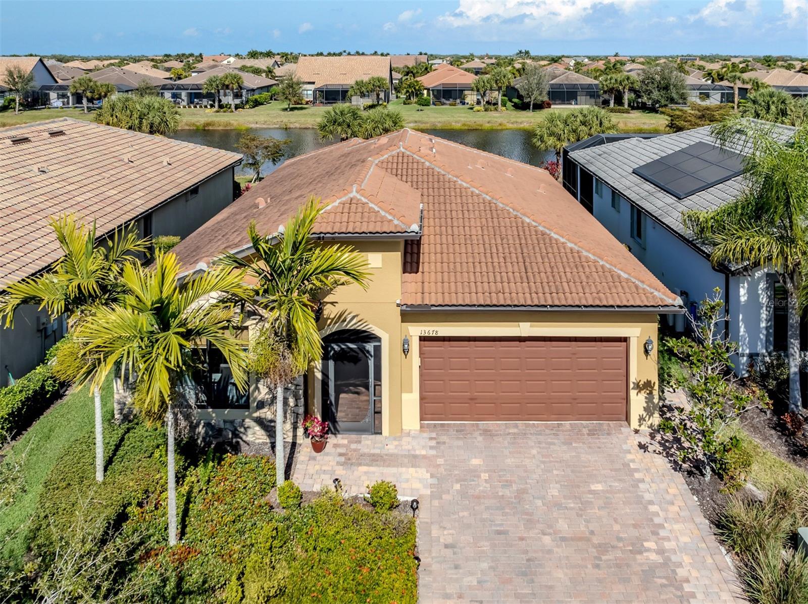 Updated Pricing- Location truly matters—and Yelma Street delivers. Tucked on a quiet cul-de-sac with a Venetian bridge at the end of the street, this home is just one street from the clubhouse and surrounded by scenic walking paths and expansive lakes. Friendly neighbors and an active community create a welcoming, social atmosphere.

This Abbeville model offers beautiful water views, high-wind impact windows and doors, and an extended lanai with clear-view screening—perfect for enjoying morning coffee. A screened front porch, stone facade, and extended brick paver driveway add to the home’s curb appeal.

Inside, the home features wood-plank tile flooring, fresh neutral paint, 8-foot doors, and a split floor plan with 2 bedrooms, 2 baths, plus a flex room ideal as a den or optional guest space. The primary suite overlooks the water and includes a large walk-in closet and an en-suite bath with dual granite vanities and a walk-in shower with an infinity glass wall.
The kitchen is both stylish and functional, offering 42-inch cream cabinetry, granite counters, a large island with designer lighting, stainless steel appliances, subway tile backsplash, and a closet pantry with a built-in spice rack. The two-car garage includes a water softener, ceiling-mounted storage rack, and an electrical panel ready for a generator.

Islandwalk is a gated, resort-style community known for its vibrant lifestyle. Residents enjoy two clubhouses, two resort pools, two lap pools, two fitness centers, pickleball and Har-Tru tennis courts, bocce, a dog park, a community garden, and miles of walking, biking, and golf-cart paths over picturesque Venetian bridges. A full-time paid social director coordinates classes, such as yoga, chair yoga, strength training, and dance, as well as monthly concerts, dances, game nights, card games, and community events.

Conveniently located near shopping, dining in Wellen Park, Atlanta Braves Spring Training Stadium, and Venice’s beautiful beaches—this home offers the perfect blend of location, lifestyle, and low-maintenance living. Request your showing today!