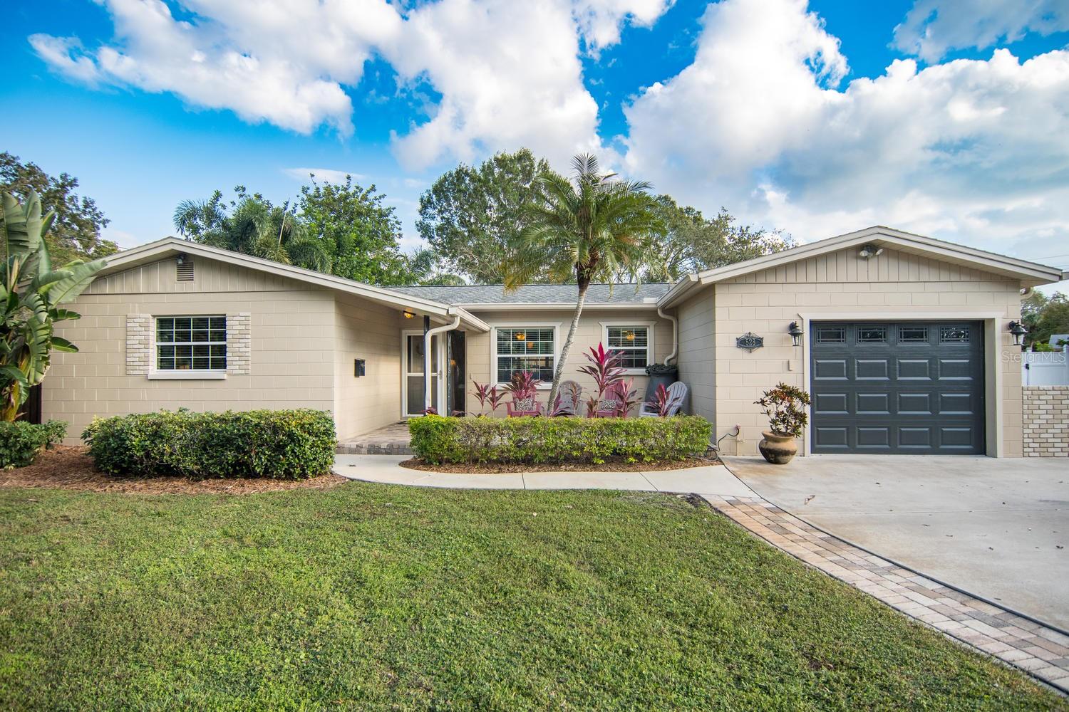 Welcome to one of the best-kept secrets in St. Petersburg! Nestled in the highly desirable Pasadena Bear Creek Estates, this exceptional 3-BEDROOM, 3-BATHROOM home is situated on one of the largest and most PRIVATE CUL-DE-SACS in the area. Set on an oversized quarter-acre pie-shaped lot in a NON-FLOOD ZONE, this property offers the perfect combination of privacy, modern upgrades, and an unbeatable location just minutes from the Beaches, vibrant Downtown St. Petersburg, and the charming Gulfport Arts District. Designed with both comfort and functionality in mind, the spacious 3-way split-bedroom floor plan features two private primary suites, making it ideal for multi-generational living, guests, or a luxurious owner's retreat. Every bedroom is generously sized, including the expansive 13' x 25' primary suite. The beautifully updated OPEN-CONCEPT KITCHEN is truly the heart of the home and will impress even the most discerning chef. Featuring premium KitchenAid appliances, custom cabinetry, abundant workspace, a wine refrigerator, and seamless flow into the living and dining areas, it's perfect for entertaining or everyday living. Step outside into your own PRIVATE TROPICAL OASIS. Surrounded by lush palm trees and a privacy fence, the backyard is designed for year-round Florida living. Relax under the impressive 16' x 12' TIKI HUT with a durable metal roof and electrical service, an ideal setting for entertaining, outdoor dining, or simply unwinding after a long day. This home has been thoughtfully upgraded for energy efficiency and low utility costs with R-30 insulation, Low-E impact-efficient windows with solar film, a variable-speed HVAC system, and a tankless gas water heater. Professionally designed closet systems maximize storage throughout the home, while the garage offers exceptional custom built-in organization. PLUS, the home offers a dedicated BUILT-IN HOME OFFICE for remote work or for a student needing a study space; it's truly a perfect workspace for today's lifestyle. Additional features include French doors opening to the backyard, a custom barn door, an automatic irrigation system, a front paver patio, and a spacious separate family room offering flexible living space. The location is second to none. Walk to Our Savior Lutheran Church and School (Pre-K through 8th grade), a highly rated elementary school, and a Fundamental High School with a Medical Magnet program. Stetson University College of Law is less than 1 mile away. Outdoor enthusiasts will love easy access to the Pinellas Trail for biking and running, while nearby Gulfport Marina, Gulf beaches, boutique shopping, waterfront dining, and the arts and entertainment of Downtown St. Petersburg are all just a short drive away. Homes offering this level of privacy, space, quality, and location rarely become available. This is Florida living at its finest.