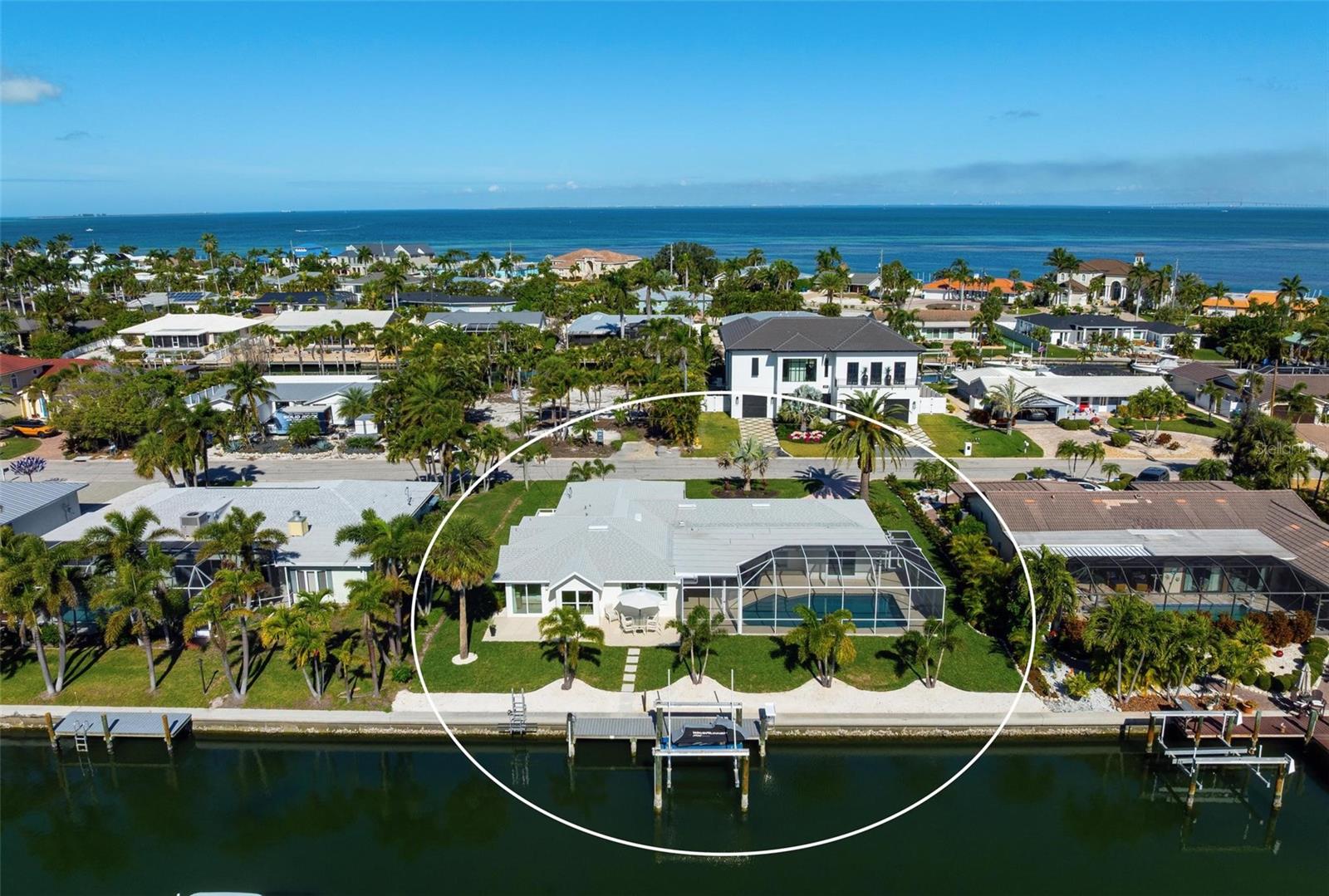 Step into effortless luxury with this meticulously renovated canal-front retreat, ideally located on 100 feet of waterfront, on an 11,543 sq ft lot in the heart of the Key Royale community. Designed for relaxed coastal living, this beautifully updated 3-bedroom, 3.5-bath home offers the perfect blend of style, comfort, and waterfront lifestyle. The home has a chef-inspired kitchen featuring wood cabinetry, quartz countertops, a gas range, wall oven, wet bar with wine refrigerator, and a generous center island perfectly suited for both everyday living and elegant entertaining. Walls of sliding glass doors bathe the interior in natural light and open to a private outdoor oasis, creating a seamless indoor-outdoor flow. Two of the bedrooms have private ensuite baths, including the primary bedroom which features a spacious bedroom with an en-suite bath with a soaking tub, a walk-in shower and an outdoor shower providing comfort and privacy. Outside, enjoy the resort-style pool designed for lounging in both sun and shade, or take in peaceful canal views framed by lush tropical landscaping.  A new irrigation system and new elegant landscape lighting have also been installed. A true boater’s dream, the property features a private dock with electric and water, plus a 10,000 lb boat lift and kayak launch, offering quick access to the sparkling waters of Bimini Bay, Tampa Bay and beyond. Additional updates include a roof installed in 2017 for added peace of mind.  Just a short stroll or bike ride from Anna Maria Island’s sugary beaches and moments from charming shops, dining, and island attractions; the location is as exceptional as the home itself. Residents of Key Royale have the option to join the private Key Royale Club, a 9-hole golf course with a clubhouse, creating a lifestyle that perfectly balances boating, golf, and island leisure. Bring your boat, fishing poles, golf cart, and clubs and start living the island lifestyle you’ve been dreaming of. This is a rare opportunity to own a truly special slice of waterfront paradise.