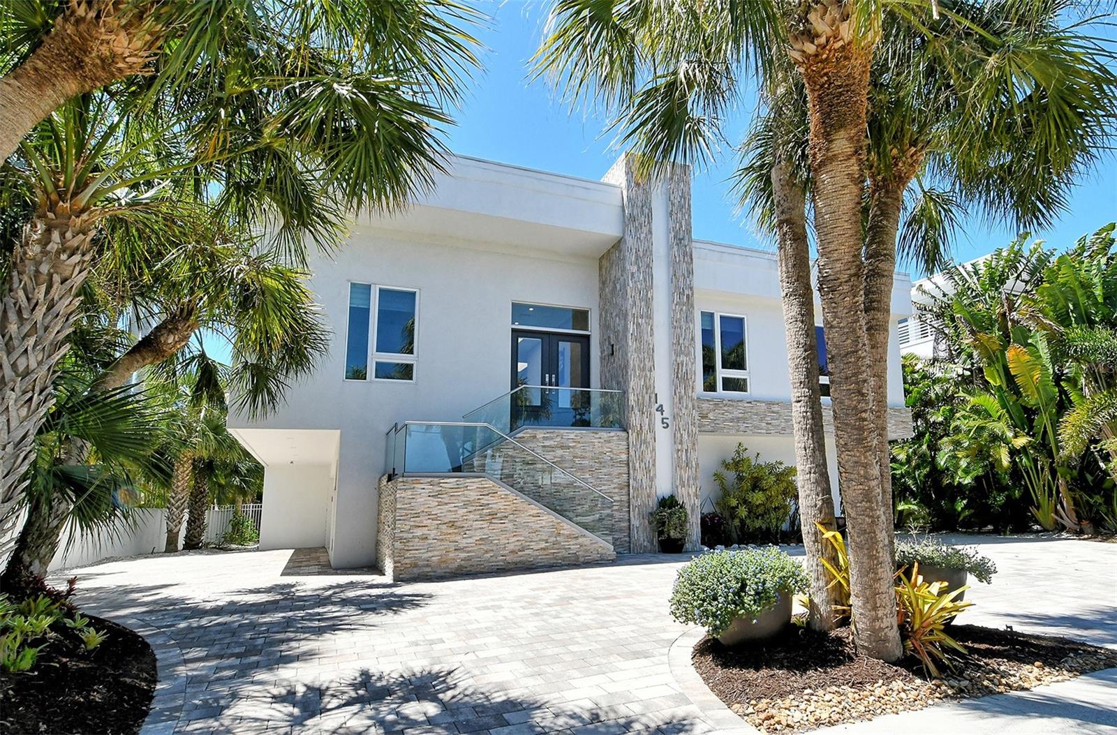 LOCATION, LOCATION, LOCATION. This home offers peace and tranquility from the moment you step in! Nestled in lush tropical landscaping this beautiful custom-built home is the perfect place to begin your Florida lifestyle. Whether you are looking for a vacation home or a full-time residence this 3 bed, 3.5 bath, pool home with 3515 sqft of heated living space is a dream come true! With the cosmopolitan St Amand’s Cir on your doorstep and a 10-minute saunter to the beach this home will certainly not disappoint! As you enter this contemporary home you will be blown away with the 10ft ceilings and large skylights allowing natural light into the spectacular living space of this gorgeous island retreat! The home flows wonderfully from the living rooms to the spacious custom chef’s kitchen from ample cabinetry with pull out drawers, quartz counters, tile backsplash, built in double oven and large center island not to mention wine storage! This turnkey furnished home was designed to perfection with floor to ceiling impact windows and sliders with electronic blinds and screens when needed. The corner sliding glass doors extends the living space to the outdoors which is perfect for entertaining family and friends or just sit back, relax and soak up the Florida sunshine! From the balcony take the steps to the downstairs entertainment area or enjoy the heated saltwater pool. The spacious master suite with subtle integrated lighting and sliders out on the balcony offers ‘His and Her’ separate washrooms, walk-in shower and two walk-in closets. With two additional guest beds both with ensuite bathrooms perfect for visiting friends and family, a spacious utility room and office/den. There is also a bonus room currently being used as a media room but can be easily changed to a 4th bedroom to accommodate any overspill visitors. This stunning home also offers an elevator, a fabulous garage for any budding car enthusiast! With garage doors on each side of the home allowing easy access in and out of the garage. There is enough space for 4 cars, or island toys. There is also an additional storage area too! The covered outdoor space at this home is perfect for enjoying the Florida weather too! Part of the space is currently being used as a gym with extra space for table tennis, or a small pickleball net! With easy access to everything Sarasota has to offer this home is perfect! Whether you fancy a morning coffee on the Circle, an afternoon at the beach, kayak at Ted Sperling Nature Park or take the free trolley ride downtown. The Arts and Culture of Sarasota cannot be beaten; from the National Ballet, the Sarasota Opera House, World class theatre shows, sports, restaurants and endless shopping you will never want to leave! Being of solid construction the home faired well during Helene and Milton.