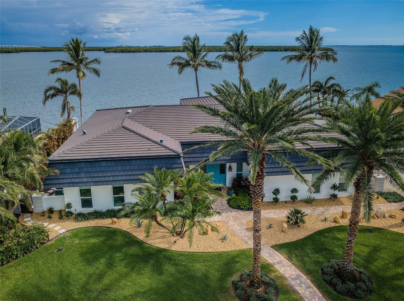 No flooding during storm. Ready for immediate occupancy. Seller will consider selling furnished for additional price.
LOCATED IN ONE OF THE FINEST BOATING COMMUNITIES IN FLORIDA, THIS SPACIOUS, SINGLE-LEVEL 4 BEDROOM 4 1/2 BATH LUXURY ESTATE RESIDENCE DELIVERS SPECTACULAR WATERVIEWS ACROSS ITS WIDE 131FT OF WATER FRONTAGE! Beautifully landscaped with towering Date/Coconut Palms, this remarkable home enjoys wonderful open spaces and a dedicated private courtyard. Beyond its graceful entry foyer and open living area, you’ll be drawn to gorgeous open water views and a dazzling infinity pool that seemingly spills into the waterway! Inspiring tilework, shiplap wall finishes, superior woodworking, and exceptional attention to detail give a lasting, lavish appeal. Grand waterfront living room with built-in surround sound transitions to large open dining. The remarkable gourmet kitchen is a sumptuous culinary delight, with exquisite coastal-white beaded-board cabinetry, graceful granite counters, elevated breakfast bar, Bosch stainless steel cooking center, and full-size pantry. Waterfront family room with spacious casual dining provides a splendid custom-built credenza. Elegant full guest bath doubles as the pool bath. Waterfront owner’s suite opens to the pool deck and features opulent wall/window treatments and spacious walk-in closet system. The lovely owner’s bath boasts granite surfaces, dual vanities, dedicated cosmetics center, hi-end fixtures, and an impressive walk-in, multi-head glass shower enclosure. 2nd and 3rd bedroom suites are oversized and private, with excellent closet systems and plush full baths. Ideal as an office/den, the 4th bedroom has rich built-ins and well-designed closet/storage. Large indoor laundry includes extensive quartz counter space, built-in wash basin, tremendous cabinetry storage, and separate closet. Step out back and discover a stunning, brilliantly-tiled, Pebbletec infinity pool surrounded by a huge travertine paver deck – all looking out to the open water. The deck/pool are elevated and the pool is supported by commercial-grade equipment. The deck offers 400sqft of covered area – perfect for outdoor dining/lounging. Composite deep-water dock with southern exposure - supports a 16K lb boat lift, jet ski lift & slip for a large cruiser. Home has extensive storage, electronic storm shutters & many updates. Best commuting waterfront location in Tampa Bay. Close to I275 - reach the beaches in 4 min, downtown St. Pete in 10 min, Tampa Airport in 25 min. An outstanding luxury value in a premier location! Buyer to verify dimensions.