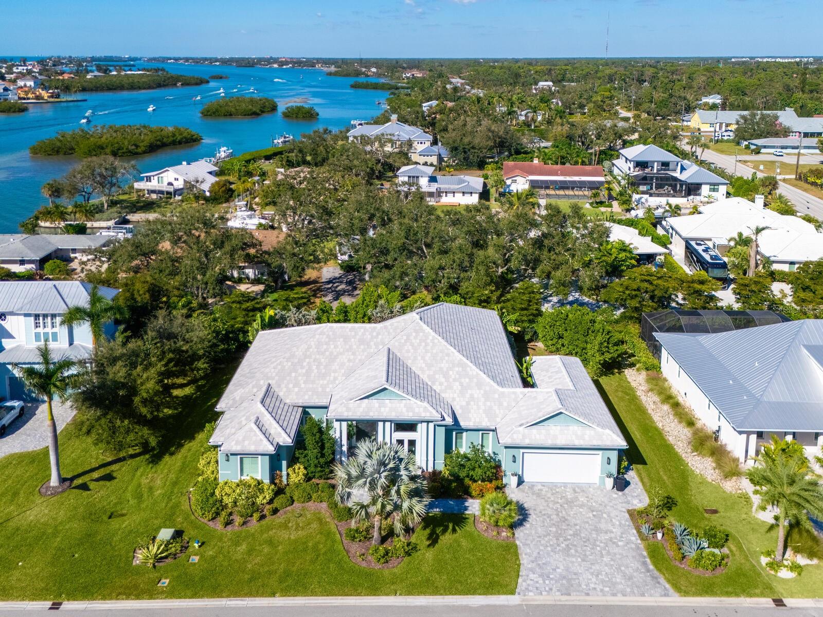 This stunning coastal-designed residence is just 0.5 miles from the exclusive Nokomis Beach, in a small, gated enclave of only seven homes. The property offers a quintessential nautical lifestyle, complete with a 30-foot dock that provides direct access to the Intracoastal Waterway and the Gulf, ideal for those who enjoy fishing or simply soaking in the serene surroundings. Built in 2020, this custom residence is a masterpiece of modern design, featuring a spacious open floor plan centered around a great room that seamlessly integrates with an exceptionally designed kitchen. The kitchen is a chef's dream, boasting abundant cabinetry with deep drawers, striking hardware and a massive island topped with luxurious quartzite slabs. This home includes three bedrooms and three baths, along with a versatile bonus/media room, providing ample space for family and guests. The owner’s retreat is particularly impressive, featuring its dedicated laundry area, designer closets and a luxurious spa-like bath. Natural light floods the interior through state-of-the-art, luxury PGT storm-rated windows and doors, complemented by transom details. The entrance is grand, featuring a remarkable 10-foot pivot front door that enhances the home's curb appeal. Every detail has been meticulously crafted, including a custom wet bar for entertaining. The exquisite shell stone flooring flows throughout the residence, adding a touch of elegance. Outdoor living is a highlight, with pocketing sliders that open to an expansive deck and pool/spa area, offering over 1,000 square feet of covered lanai space, complete with a built-in outdoor grill and sink, ideal for alfresco dining and entertaining. Additional features include a three-car tandem garage with a separate side entrance for golf carts. This exquisite home embodies the essence of Florida living, inviting you to explore and enjoy all this beautiful coastal community has to offer. Minutes to culturally rich downtown Sarasota and charming Venice, top-rated schools, dining and shopping.