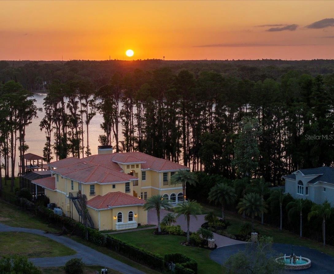 Drive down a beautiful, long, private drive to this exquisite “one-of-a-kind” lakefront estate with breathtaking views of Lake Keystone. This beautiful, gated estate is in the very heart of Odessa and is surrounded by many other beautiful lakefront estates. The western exposure of the property provides beautiful sunset views over the lake.
In addition to 5 bedrooms, 5 full bathrooms, and 2 half bathrooms, this beautiful home has a very spacious floorplan with high ceilings, a gourmet kitchen, large living room and family room, all with outstanding views of the private estate and Lake Keystone. 
The first floor includes an open formal dining room, a guest bedroom with full bath, office with lake views, game/bonus room with access to the outdoor area, home theater, wine cellar, and laundry room. Upstairs, the primary suite has an expansive view of the lake and private estate setting, along with a private balcony to enjoy morning coffee, reading a book, or watching beautiful evening sunsets. The second upstairs bedroom is an ensuite with a walk-in closet, while the third upstairs bedroom also offers its own ensuite bathroom. A second laundry room is conveniently located on the upper level as well. A nice-sized in-law suite with a full bathroom provides excellent flexibility for extended family, guests staying for longer visits, or a private separate living area, with both interior and exterior access.
Outdoor living is a central feature of the property, with over 1,100 square feet of covered space, including an outdoor kitchen, dining area, and outdoor living area with a fireplace for cozy winter days and evenings. The heated saltwater pool and spa are positioned to overlook the lake. A nice walkway leads to a lakefront firepit and private dock with covered boat slip. Schedule your showing today so you don’t miss this exceptional opportunity in Odessa. NOTE - Property is listed below its recent appraised value.