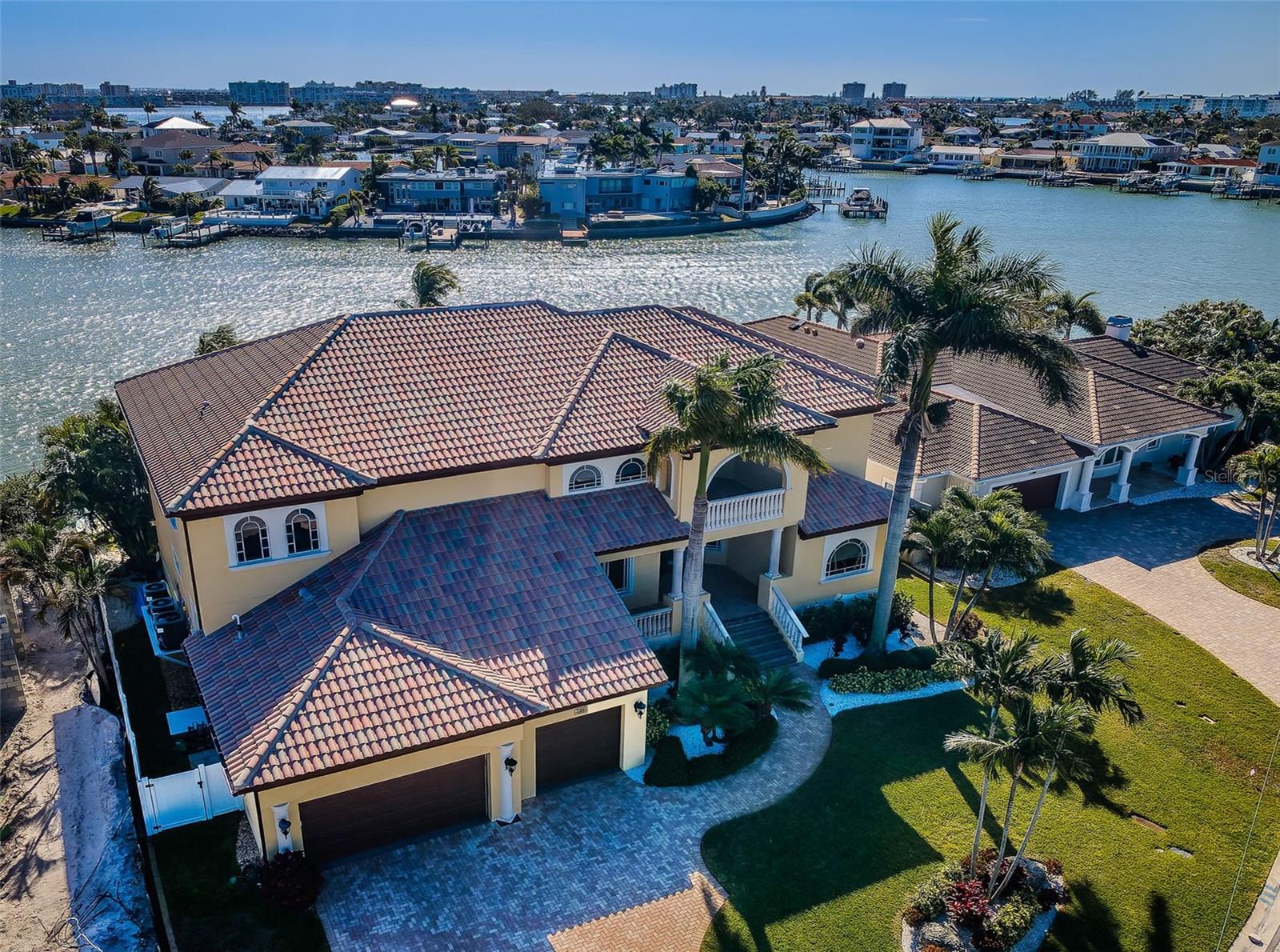 A GRAND, ELEVATED AND IMPRESSIVELY-BUILT LUXURY ESTATE WITH EASY BOATING ACCESS TO THE INTRACOASTAL WATERWAY AND THE GULF!  Beautifully landscaped with stately cast stone exterior finishes and fine wood ceilings, welcome to an extraordinary executive residence introduced by a splendid covered entry, soaring 22ft -high foyer, tall 11ft-high ceilings, and a towering sitting area overlooking the waterfront. This inspiring home offers 5 bedrooms, 5 baths and a sprawling 7969 sqft under roof. Fabulous waterviews, exceptional crown trimwork, radiant lighting and many custom designer elements deliver a posh, sophisticated and inviting appeal. The incredible gourmet chef’s kitchen is truly a joy - with coffered ceilings, custom designer wood cabinetry, dazzling granite counters, stone tile backsplash areas, Wolf/SubZero/Miele appliances with dual Fisher & Paykel dishwashers, gas cooking, an island prep center, large multi-level breakfast bar, dedicated work station, and a sizable walk-in pantry.  A massive waterfront living room opens to the pool deck and boasts lovely tray ceilings, a gas log fireplace and extensive surround sound capabilities – all supported by a custom luxury wetbar (matching the kitchen) with beverage chiller and two adjacent wine chillers.  The resplendent owner’s suite features a dedicated sitting area overlooking the waterfront and a gas fireplace.  Ready yourself to be pampered by the magnificent owner’s bath - with exquisite cabinetry, gorgeous granite surfaces, richly-honed travertine tilework/flooring, separate his/her vanities, a sumptuous built-in microjet spa tub, cosmetic center, a spectacular walk-in rain shower/steam room with body sprays, and a huge walk-in closet system with dressers.  Sizable private office with fine built-ins is suitable as a bedroom/den. Upstairs, discover a large open work area that transitions to a private, covered 200sqft deck. The substantial upper-level family area opens to a 40ft-long balcony, and is ideal for gaming/entertainment; this space includes a large custom luxury wetbar supporting the entire floor. Wanna get away? Step into the terrific media room with ample theater seating for six. All upper-level bedrooms are generously-sized and are supported by three luxurious full baths. 2nd bedroom suite opens to the balcony and includes a cosmetics center. Beyond the living room you’ll find a wonderful covered waterfront deck with built-in outdoor kitchen and brand-new gas cooking center. The paver deck transitions to a Pebbletec pool/spa with heater & salt-chlorination system.  Updated seawall and dock, 15,000 lb boat lift and extensive shore power. 2024 instant gas HW heater, 2024 whole-house water softener, lavish pool bath, EV charging port, central vac, oversized garage with extensive storage and hurricane impact windows/doors and many, many extras. An exceptional luxury waterfront opportunity in one of Tampa Bay’s finest boating communities. Dimension are estimates, buyer to verify.