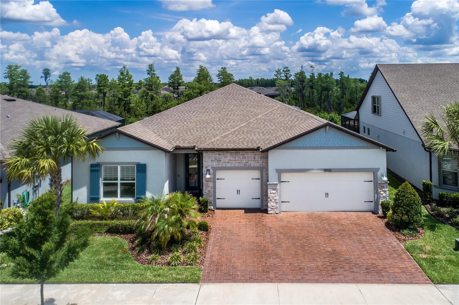 Located in the premier, resort-style 55+ community of Del Webb Bexley, this is a exceptional opportunity to own one of the largest Echelon Series homes on one of the largest lots (65 X 121) – these homes rarely come available!! This home offers serene conservation views and is located in a prime location – just 11 homes from the clubhouse and activities center!  

Built by Pulte, this spectacular 3 bedroom + Flex room (can be used as a 4th bedroom) + 3 1/2 bath + 3 car garage showcases over $115,000 in custom upgrades after the home was completed. *Enjoy maintenance-free living, the HOA fee includes monthly lawn maintenance, cable and internet*  and resort-style amenities including a 19,000 foot clubhouse, a heated zero-entry community pool and a resistance pool and spa with grills and firepit area, state-of-the-art fitness center, aerobics and dance studio, movement studio, a grand ballroom, multipurpose room, and craft room, billiards, the Bistro cafe, bocce ball courts, 6 pickleball, 2 tennis courts, community garden, dog park with separate large and small dog areas, walking and biking trails with scenic lakes and ponds plus a full-time Lifestyles team with active clubs, planned activities, an outdoor amphitheater for live performances. 

The level of upgrades in this home cannot be matched, including a $19,000+ Synergy Smart Whole House Entertainment System with CAT6 wiring, Security & Camera system and a premium surround sound system with subwoofer, a Nuvo H20 Manor Trio Water Softener System, a covered outdoor screened-in living room with Artisan “cool touch” Shellock pavers, a 375-gallon heated waterfall spa; Hurricane Shutters including motorized Armor Screen rollup, accordion, and colonial shutters, luxury beveled edge Shaw Alabaster Vinyl plank flooring, Motorized Cellar shades in all of the living areas, Plantation Shutters in the bedrooms; a Gutter System, Custom Closet by Design in the primary bedroom; a Tankless Water Heater, Upgraded chandeliers and fans; an Epoxy Garage Floor; and a custom fireplace feature stone wall with a 68-inch electric fireplace. 

The custom chef's kitchen showcases wood cabinetry, a large center island, quartz counters, a tile herringbone backsplash, a KitchenAid stainless appliance package including a gas range, two separate ovens, and a microwave combo, plus a wet bar with a wine fridge and a walk-in pantry. The family room, dining room, and kitchen are designed for entertaining, with two seating and dining areas and the built-in fireplace with shelving. Abundant natural light flows throughout the home, a triple sliding door that pockets, cathedral ceilings 11+ feet tall, tray ceilings, custom panel wall, crown molding, custom baseboards and luxury vinyl plank floors. The spacious primary suite offers gorgeous conservation views with a large sitting area, tray ceilings, and the custom primary bath highlights a double vanity with quartz counters, an oversized custom shower and spacious closets. Two additional rooms are in two separate wings of the home - each bedroom has a beautiful ensuite bath; the other flex room can be used as a den or guest room. The expansive 700+ foot 3 car garage has an epoxy floor finish, built-in shelving system, and an extended driveway with pavers offers extra space for guest parking. Located near 54 with easy access to lots of restaurants, shopping, the Veteran’s Expressway, Airport, Downtown, 45+ minutes to Clearwater/St. Pete beaches.
