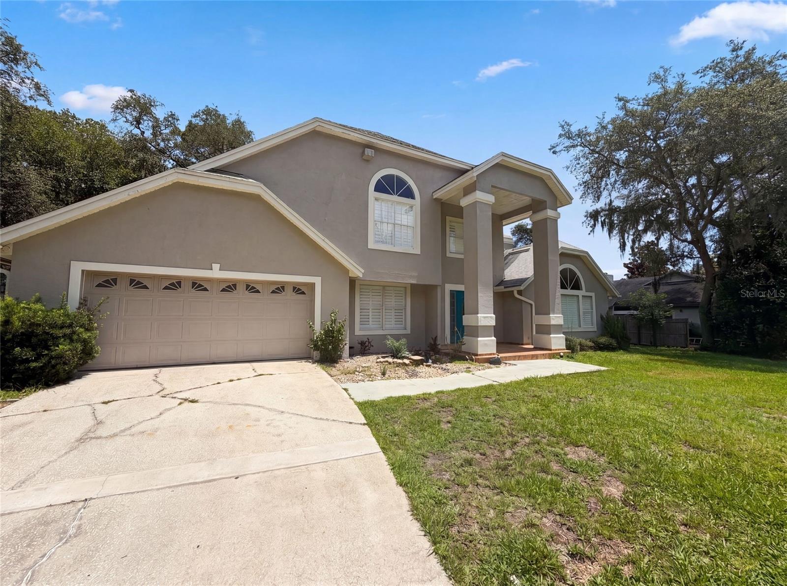 Virtually Staged. 300 Sprucewood Rd is a 2-story Lake Mary single-family home built in 1990, offering 3 bedrooms and 3 bathrooms across 2,594 square feet. The kitchen features white cabinetry, stone countertops, a center island, and stainless steel appliances. A stone fireplace anchors the living area with hardwood floors and vaulted ceilings. The primary bathroom includes a double vanity, soaking tub, and a separate walk-in shower with tile surround. The screened-in pool and back lanai provide substantial outdoor living space, and a 2-car attached garage completes this well-maintained residence.. Included 100-Day Home Warranty with buyer activation