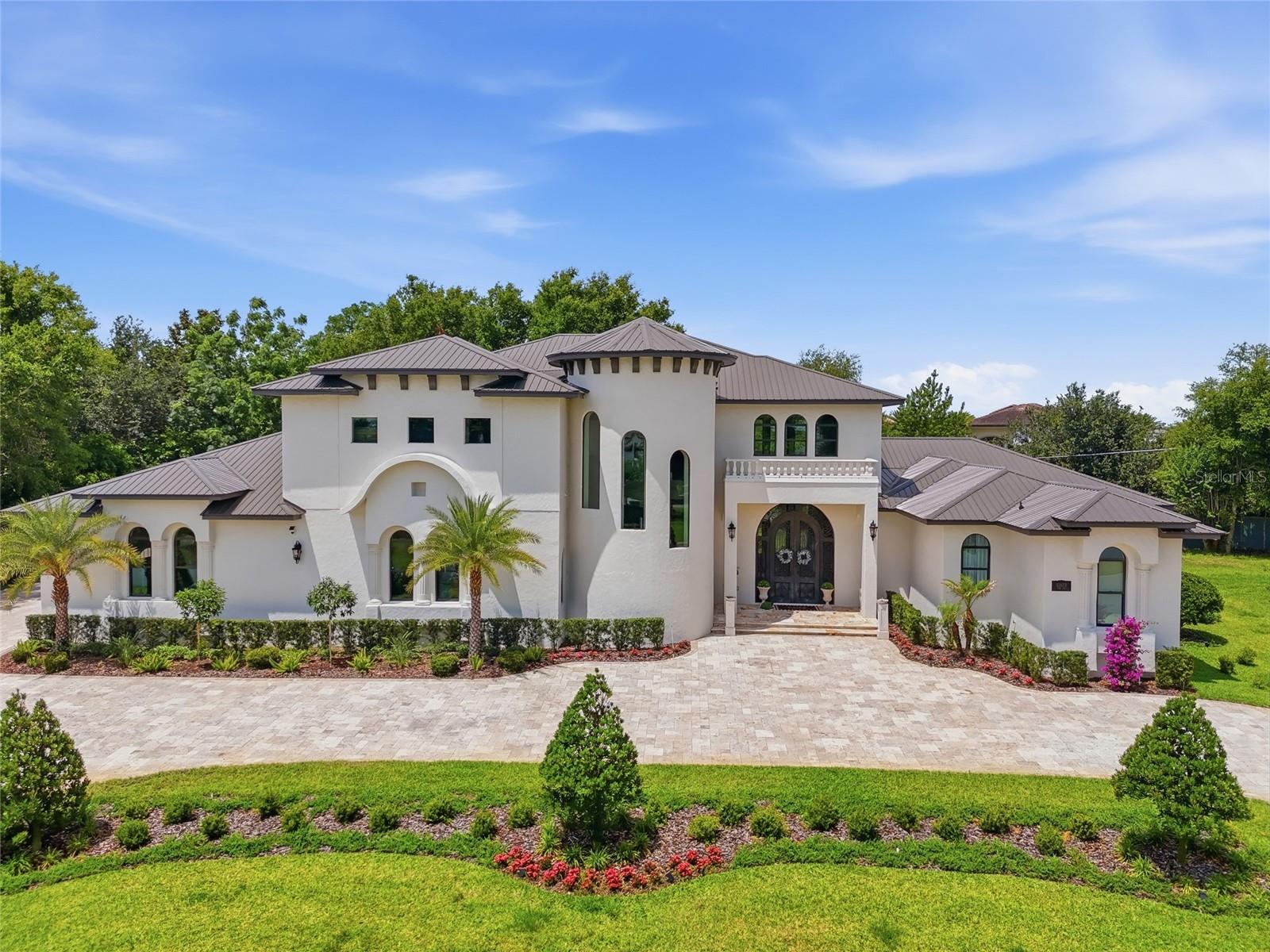 Experience Unparalleled Luxury in Chaine Du Lac
Nestled within the sought- after gated community of Chaine Du Lac, this extraordinary custom estate redefines luxury living. Offering over 7,100 sqft of meticulously crafted living space, this magnificent residence features 5 bedrooms, 5 full bathrooms, and 2 half bathrooms, combining timeless elegance with exceptional craftsmanship in one of Central Florida's most sought-after addresses.
A pair of custom wrought-iron front doors welcomes you into a breathtaking foyer highlighted by a dramatic circular dome ceiling and grand architectural details. Porcelain flooring flows throughout the home, while custom barrel ceilings, designer ceiling treatments, extensive tray ceilings, and crown molding showcase the remarkable attention to detail found in every room. Expansive windows fill the residence with natural light, creating a warm and inviting atmosphere throughout.
Each of the five bedrooms serves as a private suite, complete with its own luxurious en-suite bathroom and custom walk-in closet. Designer ceilings, elegant trim work, offering comfort, privacy, and sophistication for family and guests alike.
Designed for both everyday living and grand-scale entertaining, the chef's kitchen is truly a showpiece. Premium Thermador appliances, a custom hand-hammered copper hood, abundant cabinetry, a spacious walk-in pantry, natural gas, and stunning natural quartzite countertops combine beauty and functionality to create an exceptional culinary experience.
The outdoor living spaces are equally impressive, featuring over 7,000 square feet of premium travertine hardscaping, including a grand travertine driveway and expansive rear paver terraces. Covered outdoor living areas on both levels are enhanced by beautiful tongue-and-groove wood ceilings, creating seamless indoor-outdoor living. The expansive upstairs balcony offers the perfect setting to relax, entertain, and enjoy Florida's year-round lifestyle.
Car enthusiasts will appreciate the oversized 6-car garage, offering ample space for a prized collection, recreational vehicles, or workshop space. A private executive office has been strategically designed with a direct view into the garage, creating a unique showcase for automotive enthusiasts and allowing your collection to become part of the home's everyday living experience. 
Entertainment and lifestyle amenities continue throughout the home, including a dedicated theater room, whole-home surround sound system, and a private salon complete with its own half bathroom. A durable and elegant metal roof crowns the residence, while extensive custom millwork and luxury finishes further elevate the home's exceptional quality and craftsmanship.
Residents enjoy the prestige and security of a community patrolled by the Windermere Police Department following annexation into the Town of Windermere. Just minutes away, experience the charm of downtown Windermere, where weekly farmers markets, food truck gatherings, boutique shopping, and community events create a lifestyle as inviting as it is exclusive.
This extraordinary residence offers a rare combination of architectural excellence, luxury finishes, resort-style outdoor living, and an unmatched location within one of Central Florida's most coveted communities. A true showcase estate designed for those who demand the very best in luxury living. More than a home, it's a masterpiece of luxury living in the coveted Chaine Du Lac.