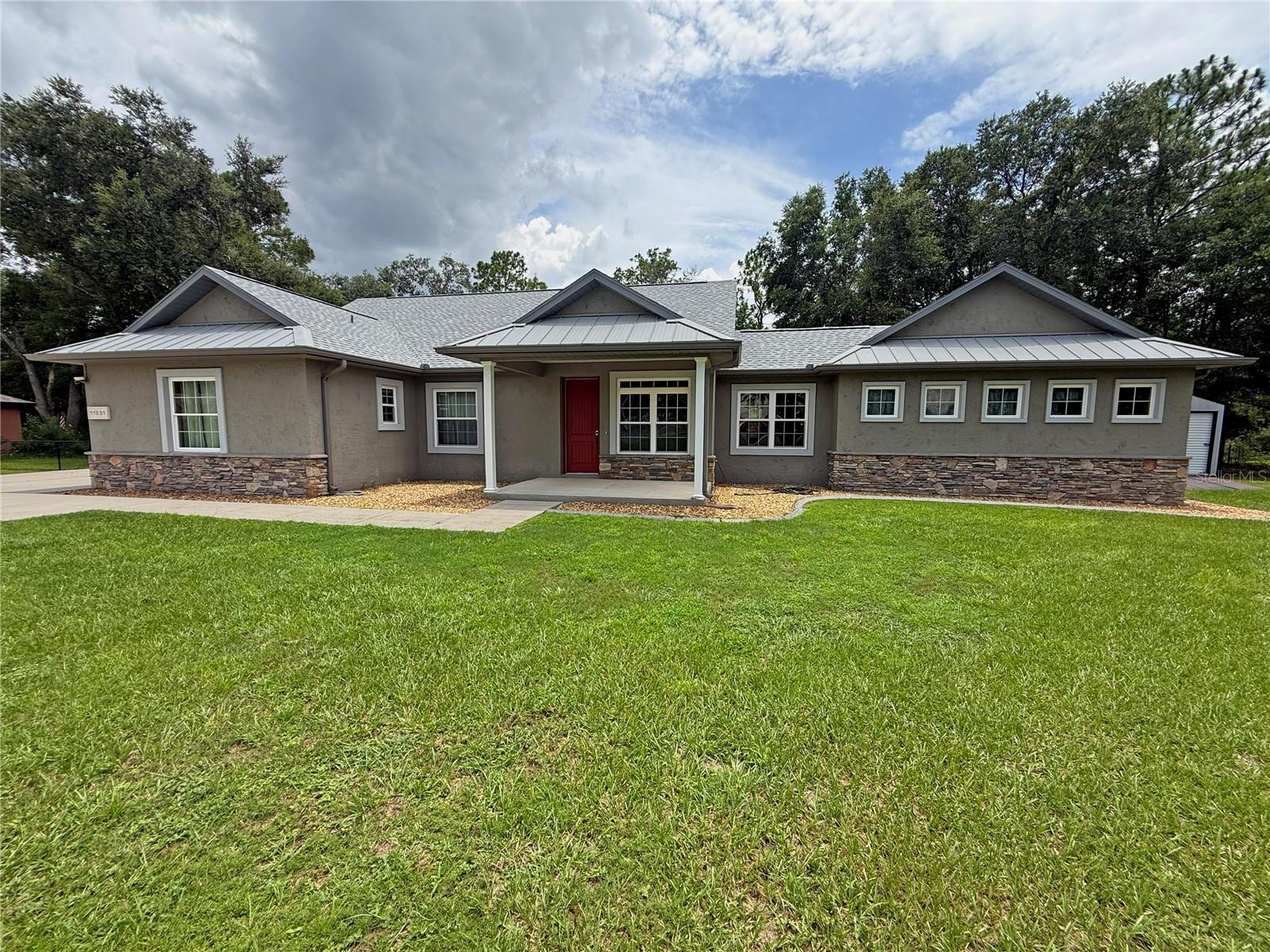 Beautifully crafted custom home ideally situated on a quiet 0.44-acre cul-de-sac lot backing directly to the Cross Florida Greenway, offering scenic natural wooded views. Constructed of concrete block and stucco, this home features an attractive modern country elevation highlighted by a welcoming covered front porch as well as a covered rear patio off of the owner's suite. Offering 3 bedrooms, 3 full bathrooms, plus a dedicated home office/den, this thoughtfully designed residence boasts over 2,300 square feet of living area with quality finishes throughout including two-way fireplace. The spacious kitchen features SS appliances, gas range for the cooking enthusiast, upgraded cabinetry, granite countertops, large center island and ample workspace, while beautiful wood flooring enhances the home's warm and inviting atmosphere. The owner's suite is a true retreat, featuring an elegant ensuite with large tiled shower and split vanities separated by a claw-foot tub. Step outside to your quiet backyard oasis featuring a covered patio pre-plumbed with a gas hook-up for future outdoor grill, screen-enclosed in-ground pool added in 2016. The fenced backyard provides added convenience while allowing for unobstructed wooded views along the Cross Florida Greenway. Recent major improvements include a new roof (2025) and new HVAC system (2025), providing peace of mind for years to come.