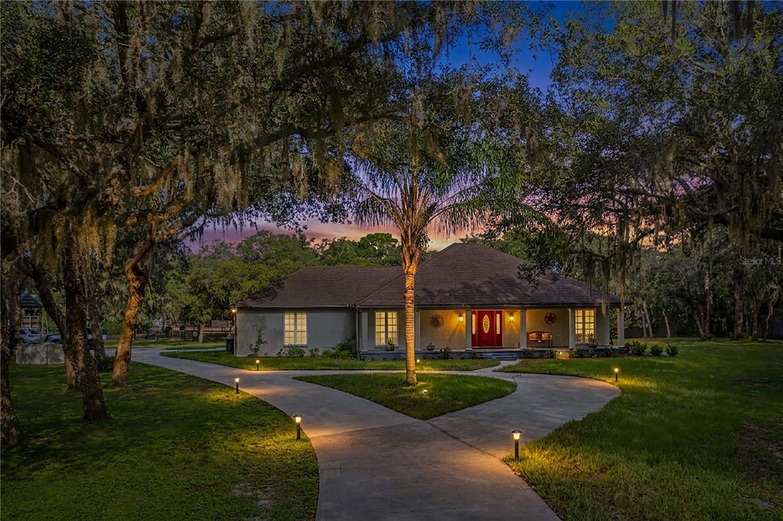 Welcome to your own private country retreat in the heart of Central Florida! Situated on 5 fully fenced acres in beautiful Haines City, this exceptional property offers the perfect combination of peaceful country living, space, and convenience. Bring your horses, farm animals, RV, boat, and all your outdoor toys—there is room for it all! A private wrought-iron gated entrance welcomes you along a picturesque driveway surrounded by majestic grandfather oaks, mature landscaping, gardens, and pastures.This charming 3-bedroom, 2-bath home features an inviting open floor plan with tile flooring throughout the main living areas and a beautifully updated kitchen offering marble countertops, upgraded cabinetry, tiled backsplash, stainless steel appliances, breakfast bar, and plenty of space for entertaining. The spacious primary suite features a walk-in closet and private bath with dual vanities and abundant storage. Two additional bedrooms share an updated guest bathroom featuring a beautiful walk-in shower.Enjoy the Florida lifestyle from the spacious screened lanai overlooking the above-ground pool and backyard—the perfect setting for entertaining family and friends or simply relaxing and enjoying the peaceful country surroundings. The former screened patio has been converted into an additional interior sunroom, providing even more versatile living space. An oversized two-car garage also includes a separate 11x7 bonus room ideal for a home office, gym, craft room, or additional storage.The property offers multiple outbuildings, including a 22x30 detached carport perfect for RV or boat storage, a 42x12 barn featuring three stalls, tack room, and feed room, plus a 10x20 building currently used as a workout area. Numerous updates include Pella double-pane windows, septic and drainfield, HVAC system, irrigation system, well pump and tank, interior paint, updated kitchen, remodeled guest bathroom, and more.Located in the desirable Marion Forest community with access to Lake Marion just around the corner, this unique property offers the tranquility of country living while remaining conveniently located to shopping, dining, major highways, and all that Central Florida has to offer. Properties offering this much land, versatility, and opportunity are a rare find—schedule your private showing today and experience the possibilities for yourself!
