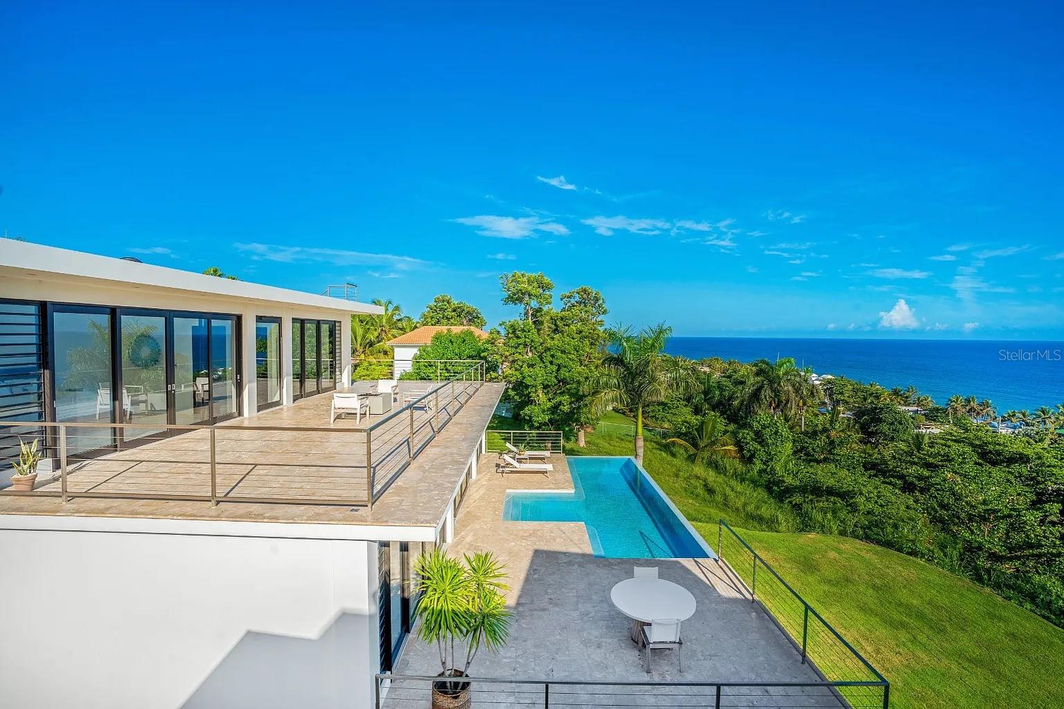 Welcome to Casa Azul—a modern sanctuary of luxury and sophistication in the vibrant town of Rincón, on Puerto Rico’s stunning west coast. Perched atop a secluded hill on an exclusive private street, this tropical paradise is an architectural masterpiece where contemporary design meets effortless functionality.

Designed by renowned architect Sarah Strauss, this breathtaking residence offers 5,000 sq. ft. of gross living area and 3,000 sq. ft. of terraces and pool space, totaling an impressive 8,000 sq. ft. of seamless indoor-outdoor living. Expansive and filled with natural light, the home’s open layout and minimalist aesthetic create an inviting atmosphere designed to enhance its panoramic ocean views. From every angle, you’ll be captivated by the beauty of nature—crashing waves, migrating whales, and unforgettable sunsets.

Step inside, and you'll be greeted by soaring ceilings and a thoughtfully designed footprint that exudes elegance and spaciousness. Floor-to-ceiling glass windows bathe the interiors in natural light while offering uninterrupted vistas of the ocean beyond.

At the heart of this extraordinary home is the expansive pool area, perfect for relaxation and entertaining. Picture yourself basking in the sunshine, feeling the ocean breeze, and listening to the rhythmic waves. The rooftop terrace provides a magical setting for gatherings, leisure, and stargazing.

Each spacious bedroom features its own beautifully designed en-suite bathroom with double sinks and a luxurious soaking tub. For fitness enthusiasts, a state-of-the-art, fully equipped gym allows you to maintain your wellness routine without leaving home.

Every detail of Casa Azul has been meticulously curated for ultimate comfort and style. A top-of-the-line solar energy system and private cistern ensure sustainability and self-sufficiency, providing peace of mind. Fully furnished and move-in ready, this exceptional home invites you to embrace the coastal lifestyle from day one.

Don’t miss the opportunity to own this modern masterpiece in one of Puerto Rico’s most coveted locations.