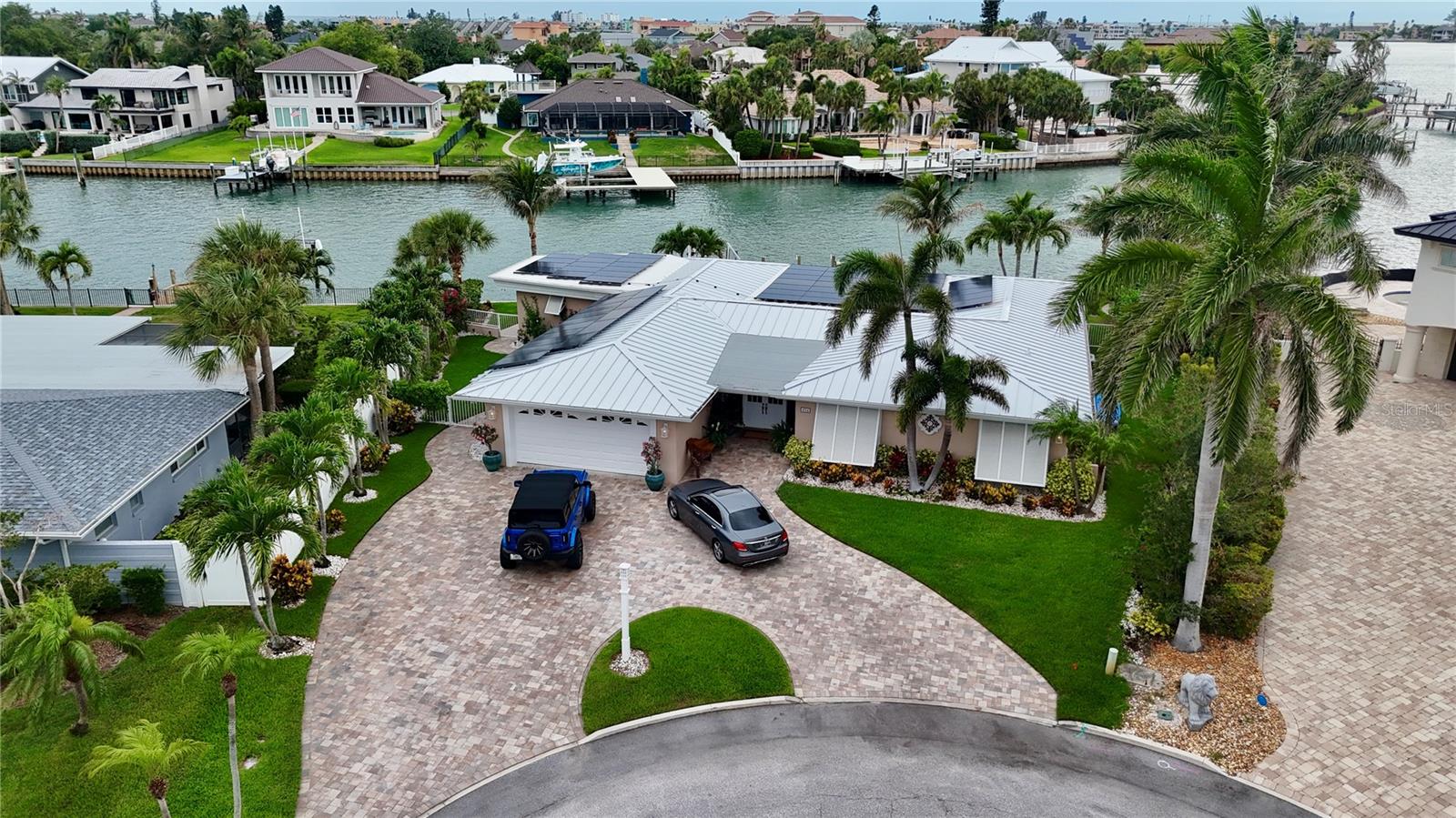Rarely available waterfront corner lot in the coveted Tierra Verde community — this meticulously updated 3-bedroom, 3.5-bath residence delivers the ultimate Florida lifestyle. With 2,576 SF of air-conditioned living space and 3,885 SF under roof, the oversized covered patio and air-conditioned 2-car garage provide exceptional additional living and entertaining space beyond what the AC square footage reflects.

Situated on a deep-water canal with a massive sea wall, the property was fully refreshed in 2020 with a new sea wall, dock, and boat lift — making it an instant-access boater's dream. The large private pool anchors the outdoor living area, complemented by a large fireplace on a dedicated paver pad — perfect for entertaining under the stars. Serene water views surround you from virtually every angle.

Inside, the open floor plan has been transformed with a fully updated kitchen, renovated bathrooms throughout, and refined finishes that honor the home's mid-century bones while delivering a contemporary feel. Peace of mind comes standard with a brand-new standing seam metal roof installed in 2025, a new paver driveway (2020), and all major water infrastructure — sea wall, dock, and boat lift — replaced in 2020.

Tierra Verde is a highly sought-after island community minutes from Fort De Soto Park, Passa-Grille Beach, and St. Pete Beach — with easy access to downtown St. Petersburg and Tampa. Live where others vacation. Hurricane-rated storm shutters covering every window and door were installed in 2022, providing exceptional storm protection and insurance benefits.