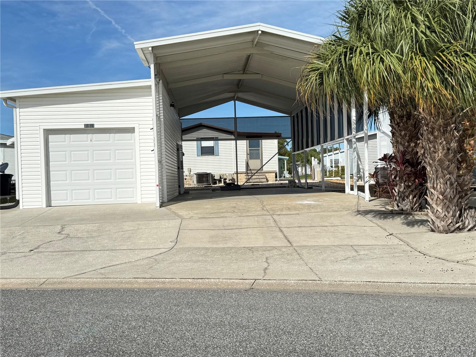 This large RV lot has a roof over, room for your Class A motorhome (17.5' x 42') and a full garage (12.5' x 38').  The garage door is automatic and has 2 remote openers.  Electric service is 50-amp and there is a sewer hookup for your RV.  The garage has ample room for a full-sized car/truck and room for a shop and the washer & dryer.  There is plumbing in the garage with a laundry sink and an outlet for a toilet.  Deep within the park, this lot is the perfect place to chill.  Just down the road is a relaxing pond full of wildlife.  Access to all amenities is a short one-block walk.  This is the life.  
American Condominium Park is a 55+ gated community with heated pool, clubhouse, exercise room, sauna, hot tub, tennis/pickleball courts, horse shoe pits, shuffleboard, and many more amenities.  A friendly active community with dances, dinners, and entertainment.  Perfect for full time affordable living and cost effective for snow birds.  NO RENT AS YOU OWN THE LAND!  Reasonable monthly fee that maintains the common elements and amenities for your use.  As an RV subdivision this property has full hookups.  Just park your RV and enjoy!