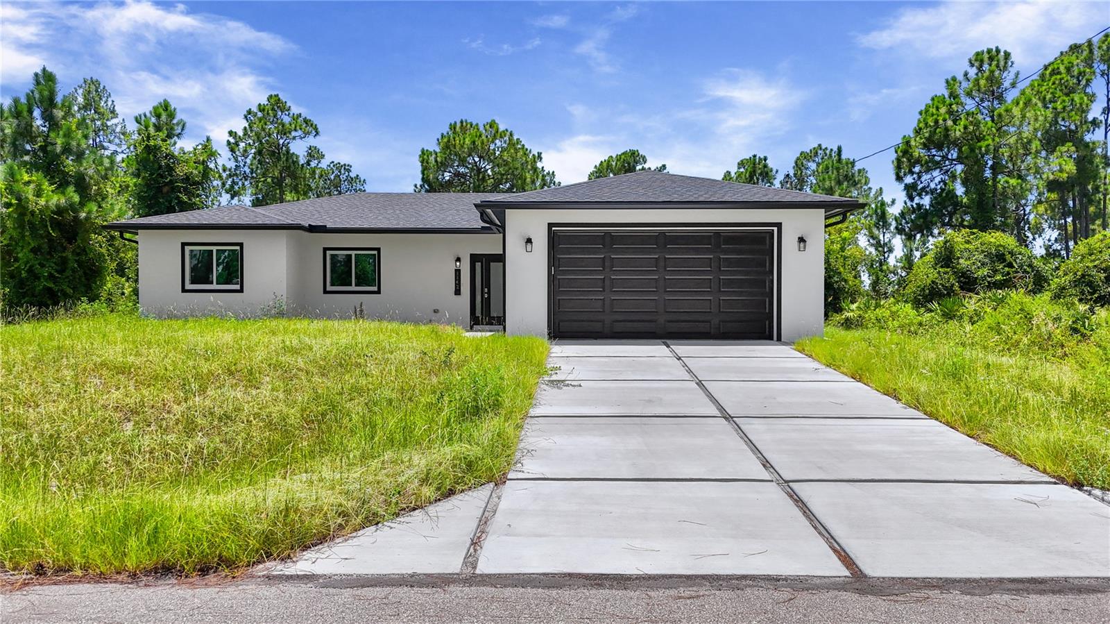 Welcome to this brand new 2026 built home offering 4 bedrooms and 3 baths (2 full, 1 half) across 1,632 sq ft of living space, set on a spacious .24 acre lot. Inside, the kitchen is a true showpiece, featuring a massive waterfall edge island, sleek white cabinetry, quartz style counters, and a full suite of stainless steel appliances including a range, dishwasher, disposal, and self cleaning oven. It opens seamlessly into the great room and dining area, all finished with elegant tile flooring throughout. The split bedroom layout offers privacy and flexibility, with a primary suite featuring a spacious walk in closet and an en suite bath with a glass enclosed shower, while the remaining bedrooms are thoughtfully separated, each with generous closet space. Additional features include an interior laundry, and a covered lanai/porch overlooking the backyard. Impact resistant doors and sliding windows, and an attached 2 car garage. Built for comfortable, low maintenance living, and located in a no subdivision setting in Southeast Lehigh Acres, this move in ready new build offers a great opportunity for buyers seeking modern construction with room to make it your own.