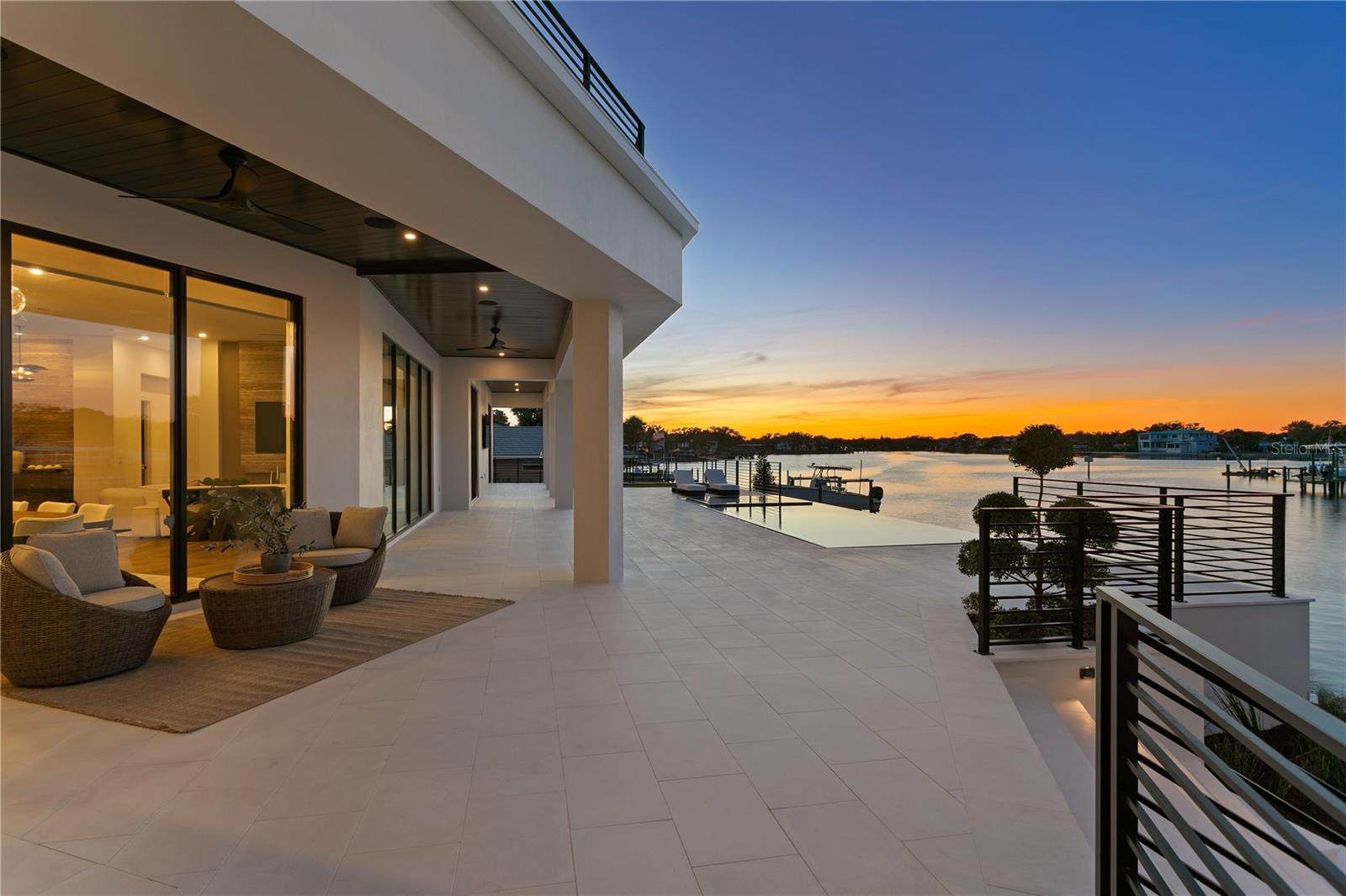 Welcome to Snell Isle Estates, St. Petersburg’s most exclusive waterfront enclave—where architectural distinction, serene privacy, and expansive open-bay panoramas converge.

Crafted by Paragon Waterfront Homes in collaboration with Verve Design Co., this newly completed residence sets a new benchmark for contemporary coastal living. Tucked within a private cul-de-sac peninsula, each estate in this rare collection commands approximately 155 feet of pristine waterfront, designed to celebrate Florida’s seamless indoor-outdoor lifestyle.

Inside, refined craftsmanship defines every space. European oak flooring, white oak staircases, custom all-wood cabinetry, and dramatic travertine and marble feature walls create a timeless yet modern aesthetic. The chef’s kitchen is a statement of both form and function, appointed with Wolf, Sub-Zero, and Cove appliances, quartz, quartzite, and travertine surfaces, a full bar with ice maker, and meticulously curated architectural detailing.

Designed for effortless living and entertaining, the home features 12-foot ceilings on the main level, 10-foot ceilings upstairs, a three-story elevator, gas fireplace, Control4 home automation, Lutron automated shades, and ES low-E, high-efficiency windows and doors. Comfort and resilience are elevated by a whole-house water softening system by One Green Filter, dedicated RO drinking water, and a full backup generator.

The expansive three-car garage boasts 16+ foot ceiling heights, ideal for vehicle lifts and serious collectors.

Outdoors, the property transforms into a private waterfront retreat, featuring a fully equipped outdoor kitchen wrapped in sunshades, lush landscaping irrigated by reclaimed water, and a dock setting for a 24,000-lb boat lift—ready for life on the bay.

With only a limited number of opportunities within Snell Isle Estates, this residence represents the future of luxury living on Snell Isle—a quiet powerhouse at the forefront of St. Petersburg’s next era.