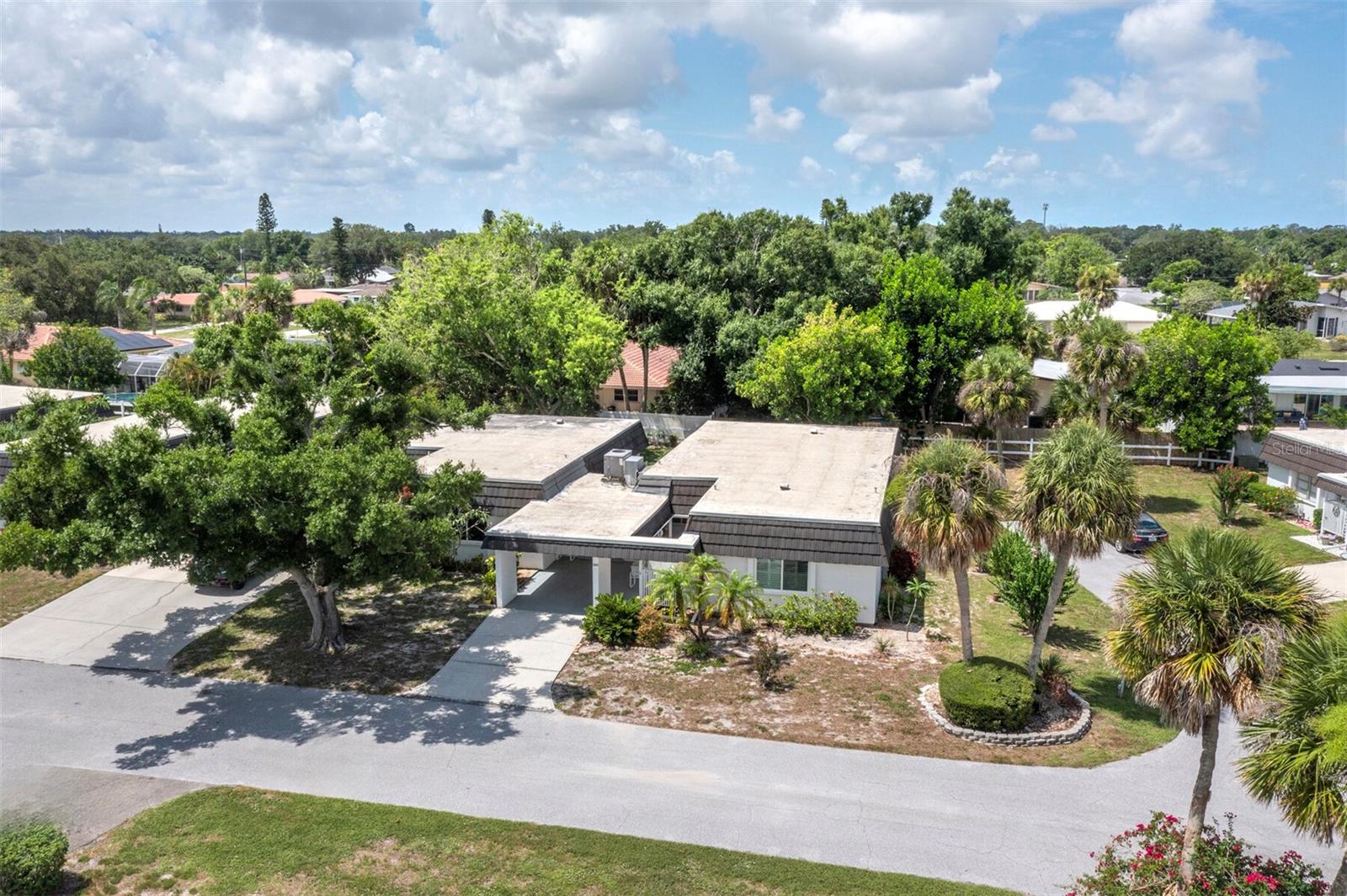Welcome to Glen Oaks Ridge, a sought-after 55+ community where resort-style amenities meet a peaceful, natural setting minutes from the heart of Sarasota. This pristine, move-in ready 2 bed, 2 bath end-unit villa offers the space and privacy of a single-family home, without the upkeep. Step through the screened breezeway and etched glass front door into a home that feels warm and welcoming from the moment you arrive. Inside, an open floor plan and abundant natural light create an inviting feel, with living, dining, and kitchen areas connecting effortlessly. A light-filled Florida room and flexible bonus room/den add space to work, create or unwind. The primary suite offers a walk-in closet and private en-suite bath, and a second bedroom with full guest bath welcomes visitors. As an end-unit, there's no shared driveway and only a laundry wall connects you to your neighbor for true single-family privacy. Glen Oaks Ridge offers something for everyone including a clubhouse, fitness center, heated pool overlooking the lake, library, card rooms, shuffleboard, putting green, and a newly added lawn bowling facility. Residents enjoy a full calendar of social activities, from game nights to group outings. The community is adjacent to Bobby Jones Golf Course and its new recreation complex with nature trails, and just a short drive to UTC Mall, downtown Sarasota, St. Armands Circle, and the beach.