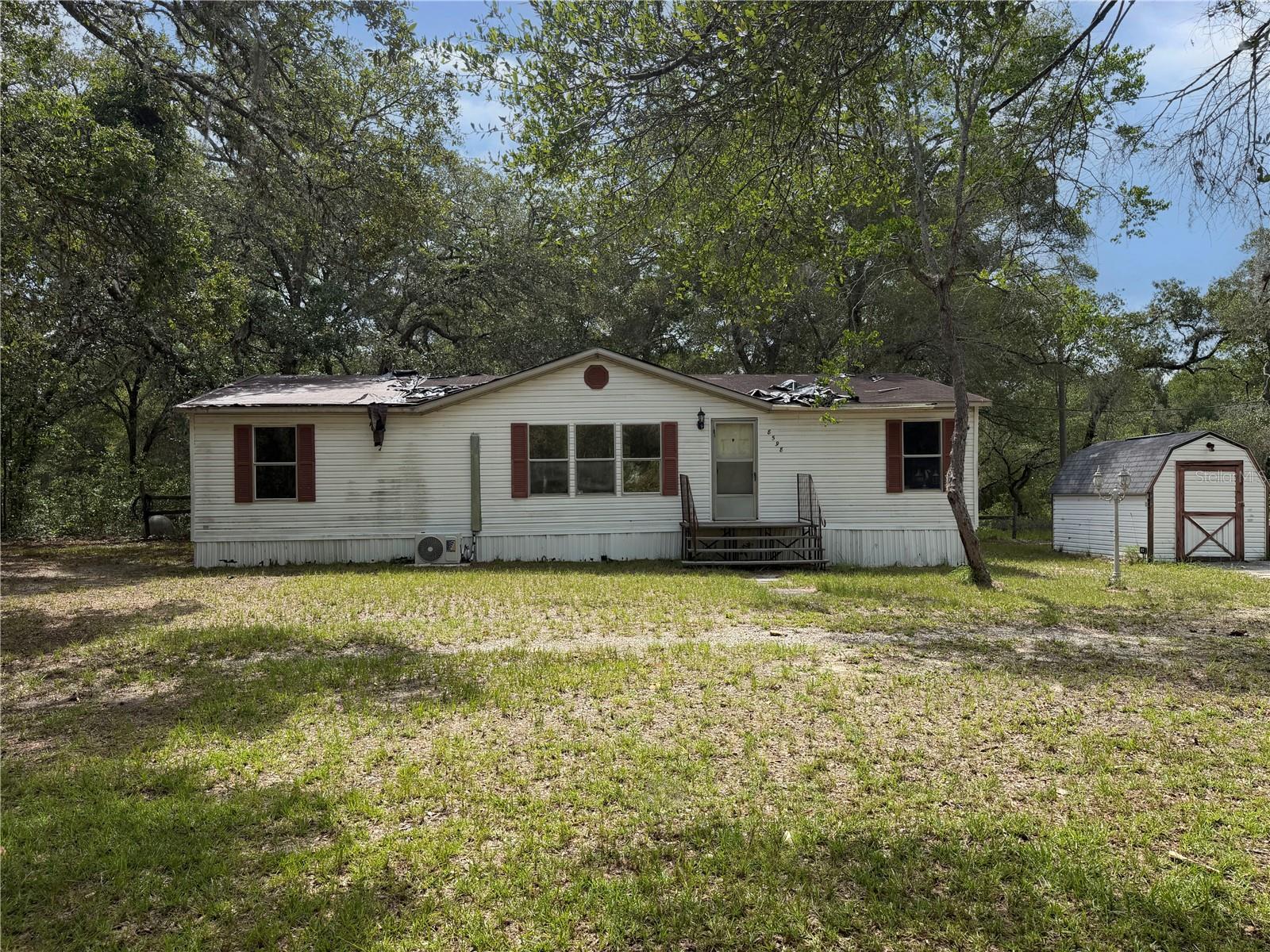 So much potential in this Dunnellon fixer-upper! Located between Dunnellon and Crystal River on a quiet dirt road with a peaceful, tree-lined 2.5 acre lot and large circular driveway in Mini Farms Unit 17. This 3 bedroom 2 bathroom 1998 manufactured home offers solid bones, country charm, and space to create your dream retreat. The property comes equipped with some back yard fencing, a storage shed and is situated in an X flood zone even though it's only a short drive away from Crystal River.  Perfect for investors, DIY buyers, or anyone ready to build equity and enjoy the laid-back Florida lifestyle! Enjoy small-town charm and nature just minutes from Crystal Rivers shops, dining, and outdoor adventures. You can also enjoy all the other great recreational activities Dunnellon and Crystal River have to showcase; biking, hiking, fishing and kayaking. No HOA fees or regulations. Call today to schedule a showing!