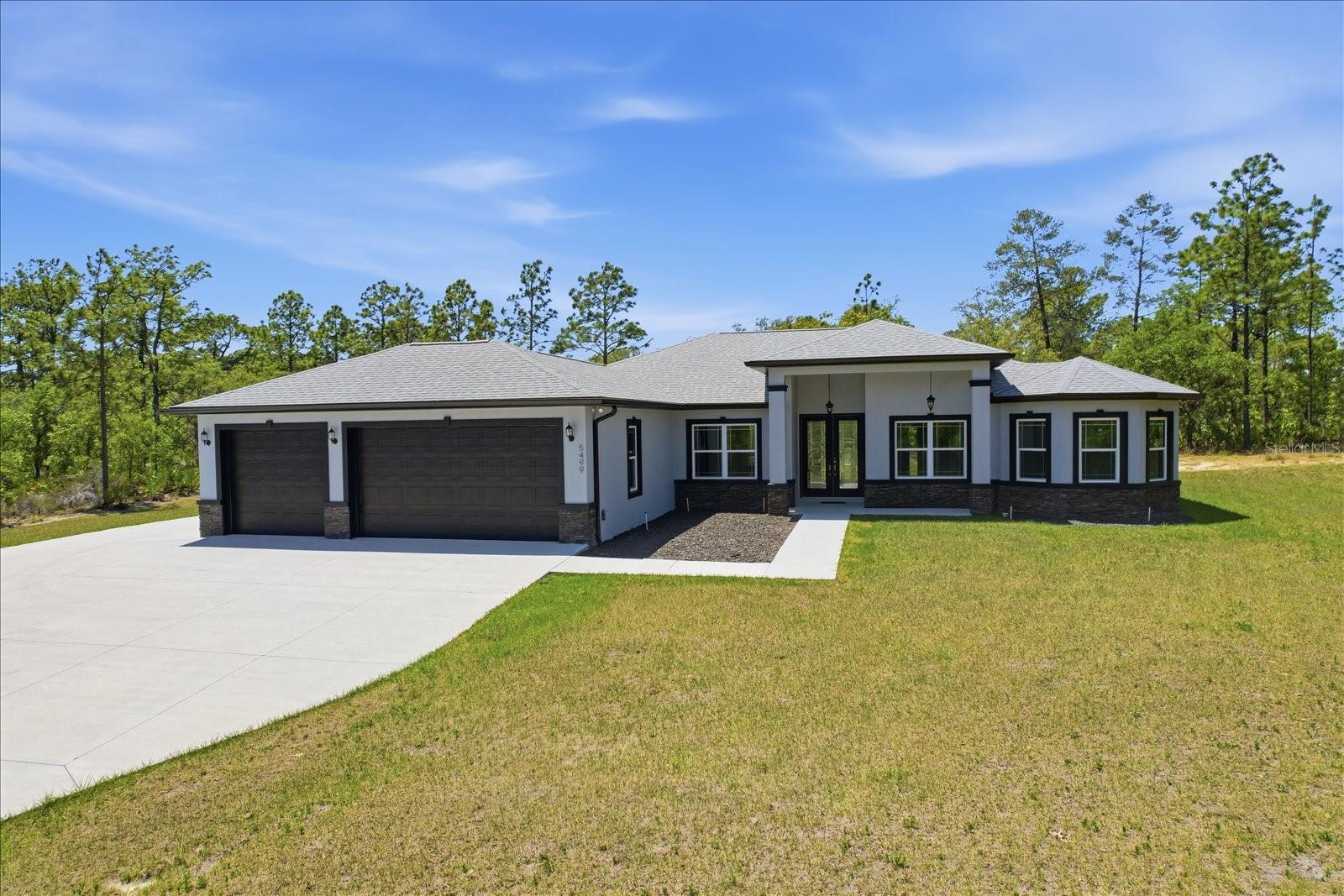 NO NEED TO WAIT ON CONSTRUCTION! THIS NEVER LIVED IN 2025 HOME IN PINE RIDGE HAS SPACE TO SPREAD OUT, MODERN STYLE, AND TRULY STANDS APART! Step into this stunning 2025 custom-built 3 bedroom (plus office), 3 bath, 3 car garage home in Pine Ridge where every detail feels intentional from the moment you arrive. The stacked stone pillars and grand double door entry welcome you into a bright, open floor plan with soaring tray ceilings and beautiful luxury vinyl plank flooring throughout. The living room is spacious and inviting, complete with a custom built-ins for your entertainment center, and flows seamlessly into a show-stopping kitchen featuring white cabinetry, a massive curved island with dark countertops, double built-in ovens, a gas cooktop with a sleek stainless range hood, modern statement lighting, and huge pantry. Natural light fills the home, including a beautiful dining nook surrounded by windows overlooking your private, tree-lined lot. This 3 bedroom (plus office), 3 bathroom split floor plan offers a true retreat in the oversized primary suite with tray ceilings, dual walk-in closets, and a spa-like bathroom featuring double vanities and an elongated walk-in shower with upscale finishes. Even the laundry room is thoughtfully designed with built-in cabinetry, workspace, and a utility sink. A dedicated pool bath is already in place, making it easy to create your future backyard oasis, while the oversized 3-car garage, extended driveway, and expanded concrete pad add both convenience and durability. High and dry, no flood insurance required. Located in the highly sought-after Pine Ridge community of Citrus County, residents enjoy 28 miles of equestrian trails, stables, riding areas, tennis courts, and a community center. Zoned for Central Ridge Elementary School, Citrus Springs Middle School, and Lecanto High School. Conveniently located with easy access to both Citrus and Marion Counties and the Suncoast Toll Road ramp is just outside the entrance to Pine Ridge, so you can be to the Tampa Airport in just over an hour! This property offers the perfect balance of privacy, recreation, and accessibility, all within Florida’s beautiful Nature Coast. Don't let this one get by!