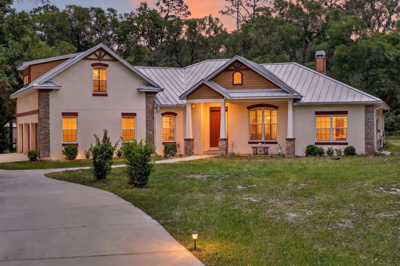 Welcome to 1806 Glenwood Oaks Lane, a private custom-built retreat tucked away on 2.5 acres in the desirable Glenwood Oaks community, perfectly situated on a quiet cul-de-sac. Built in 2017, this modern ranch offers over 3,300 sq ft of thoughtfully designed living space, combining luxury, durability, and functionality. Step inside to find an open-concept layout highlighted by soaring vaulted ceilings with crown molding, wood-look tile flooring throughout the main living areas, and abundant natural light. The gourmet kitchen truly serves as the heart of the home, featuring custom wood cabinetry, granite countertops, pull-out drawers, a natural gas range, tile backsplash, under-cabinet lighting, and a spacious walk-in pantry. The kitchen overlooks the inviting family room, complete with a gas fireplace and stunning floor-to-ceiling stone surround, perfect for entertaining. The split floor plan offers 4 bedrooms, including a private primary suite tucked away for ultimate relaxation, along with generously sized secondary bedrooms featuring ample closet space. Upstairs, you’ll find a one-of-a-kind game room built for entertaining, showcasing Cumaru (Brazilian Teak) hardwood flooring, an Epson projector with surround sound, and reinforced construction with 16,000 lb trusses, ideal for hosting unforgettable game nights. Enjoy seamless indoor-outdoor living with triple sliding glass doors leading to a screened Florida room, perfect for BBQs, relaxing evenings, or enjoying the hot tub while overlooking your expansive, wooded backyard. This home was built with unmatched quality and safety in mind, constructed with solid poured concrete (3000 PSI with fiber mesh), rebar-reinforced block walls, storm-rated windows, and a full-core fiberglass door, effectively making it a true safe room. Additional upgrades include a 50-year metal roof WITH 20 YEARS REMAINING ON THE WARRANTY, PGT vinyl low-E windows, a natural gas tankless water heater, and a whole-home water softener/purification system. CURRENT INSURANCE COSTS ARE APPROXIMATELY $2,500 PER YEAR.  For those needing extra space, the property also features an over-engineered RV shed rated for 150 mph winds, built on deep concrete piers, complete with dual 50-amp hookups. A detached shed adds even more storage or workspace flexibility, while the expansive acreage provides endless opportunities for outdoor living, recreation, or future additions. If you’re looking for privacy, quality construction, and a property built to stand the test of time, this is it. Schedule your private showing today!