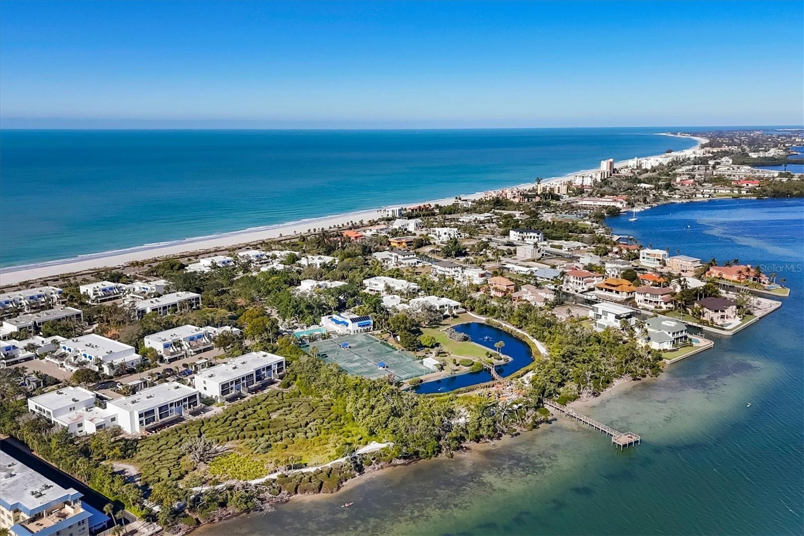 Poised within the Gulf to Bay community of Bayport Beach and Tennis Club, 842 Bayport Way offers 1570 square feet of effortless indoor-outdoor living. This comfortably furnished first floor corner residence gives the feeling of a private home with the ease of low maintenance living. A favorite feature of this property is the screened lanai that opens to a west facing extended brick patio. Perfect for easy mornings and catching brilliant sunsets. Step out the garden gate to landscaped grounds and a direct path to deeded beach access across the road. For pet owners, Bayport is small-pet friendly, and this walk-out location makes dog-walking especially easy. Inside, The open layout includes a spacious kitchen, combined living and dining, a primary bedroom with office nook, ensuite bath with dual vanities and walk-in closet,second bedroom and full bath,  plus the convenience of full sized in unit laundry, covered parking and private storage closet. There is also a brand new high efficiency HVAC system and a 2023 hot water heater.   
 Bayport is celebrated for its timeless Tim Seibert architecture, exceptional amenities, and easy resort lifestyle. Residents enjoy a heated Jr. Olympic pool, clubhouse, fitness center, tennis, bocce ball, and shelled walking paths among 27 acres of exquisitely landscaped tropical grounds,. Along the bay shoreline, a fishing pier, kayak launch and storage is perfect for morning paddles or simply enjoying nature . On the Gulf side, 1,200 feet of deeded beach access, complete with loungers and umbrellas, makes enjoying Longboat Key’s famously uncrowded beaches effortless. 
The condo has rented off-season for several years and has everything one needs to start enjoying right away.  A favorable rental policy offers excellent income opportunity. Located mid-key, Bayport keeps you close to shopping, daily conveniences, great island dining, and the vibrance of Sarasota, all while feeling tucked away and serene. Settle in and enjoy a slice of true paradise on Longboat Key.