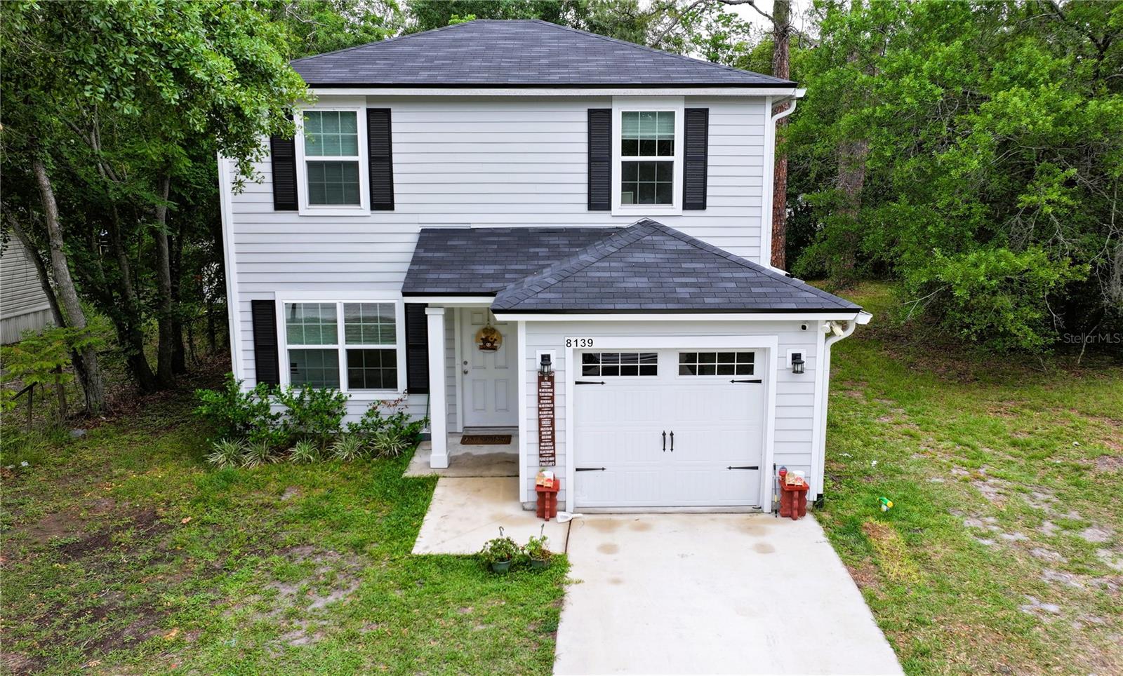 Discover a home that feels like a fresh start the moment you walk in. This beautifully maintained newer construction offers 4 bedrooms, 2.5 baths, and a layout designed for comfort, convenience, and everyday ease. The welcoming front exterior leads into a bright, open interior filled with large windows, LED cam lighting, and storage closets that keep life running smoothly.

The spacious eat-in kitchen is the heart of the home, featuring stone countertops, dark shaker-style cabinetry, and room to gather, cook, entertain, and connect. The primary bedroom is privately tucked on the first floor, complete with its own en-suite bathroom, while a half bath on the main level adds convenience for guests. Upstairs, the additional bedrooms offer flexibility for family, hobbies, or a dedicated workspace.

Step outside and enjoy a yard that strikes the perfect balance—space to plant, play, or unwind, without the upkeep of an oversize lot. Mature trees along the back create a natural sense of privacy. A one-car garage, paved driveway, and a whole-house water filtration system add even more value, and select furnishings may be negotiable.

Live close to everything that makes Jacksonville such a dynamic place to call home—approximately 20 minutes to NAS Jacksonville, 25 minutes to Downtown, 30 minutes to Baptist Medical Center, and 35 minutes to the beaches. Shopping, dining, parks, and major retailers are all just minutes away, making daily life wonderfully convenient.

This home has been thoughtfully cared for, and is truly move-in ready. Schedule your showing today—this one is too nice to last.