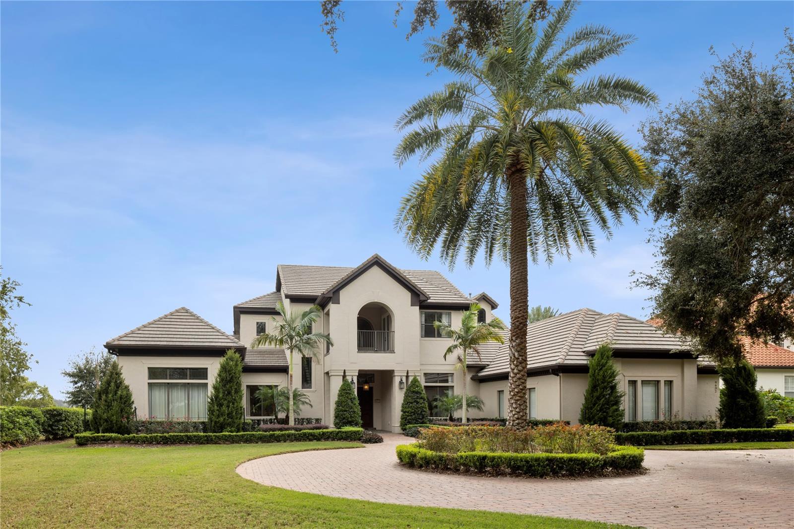 Welcome to your serene custom estate, offering unobstructed water views at every turn, situated on the shores of Lake Olivia within the gated community of Weatherstone. Just minutes from downtown Windermere and Orlando's premier attractions, this property combines luxury and convenience.  As you approach, a circular paver driveway and stunning Florida landscaping set the stage for elegance. Recent enhancements, including fresh paint inside and out and new landscaping in both the front and back, elevate the home's appeal. The open formal space invites you in with sweeping lake views through a wall of glass doors. A unique expansive wing features a spacious primary bedroom with panoramic water vistas, a private library/office, a gym/studio, a morning bar, and a meditation patio, along with an impressive dressing area complete with custom built-ins.The spa-like bathroom has been newly remodeled to include an extra-large shower with multiple body sprays and a rain shower, alongside dual custom vanities, and ample storage. The exquisite chef’s kitchen boasts a Viking gas range, double ovens, a warming drawer, an oversized island, and a custom walk-in pantry, seamlessly flowing into a generous breakfast nook and family room. Adjacent to the kitchen, a custom butler's pantry features two wine refrigerators and cabinetry. Recent upgrades include a new refrigerator, dishwasher, and microwave, as well as two new garbage disposals.  For entertaining, the first-floor movie theater with Dolby Atmos surround sound featuring 13 speakers and a 4K projector with a 130” screen.  While the waterfront billiards room, complete with a full bath and bar are great for family game nights. Additionally, another ensuite bedroom on the first floor offers a full bath and large closet. The home's new outdoor kitchen, new gas fire pit, and outdoor sound system enhance your outdoor entertaining experience.  Upstairs, you will find three more ensuite bedrooms, each with private baths and balconies overlooking the picturesque water or landscaped grounds.  The home is replete with abundant storage and numerous designer upgrades, including coffered ceilings, crown molding, and custom window coverings throughout.  The breathtaking lanai area features a full summer kitchen, an infinity-edge pool, and extensive covered entertaining spaces, perfect for year-round enjoyment. The pool and spa have been refinished with a new surface and coping, complemented by a new saltwater system with automatic app control. The expansive backyard, adorned with mature landscaping and 100 feet of private frontage on Lake Olivia, creates an ideal setting for boating, fishing, paddle boarding, and more, with a new Trex dock equipped with a boat lift and two jet ski lifts.  Additional features include a dog run with artificial turf for easy cleanup, three new tankless water heaters, new washer and dryer, closet organizers throughout the house.  The garage boasts a new epoxy floor and two new garage door openers.  A mosquito misting system covers the entire house and backyard, ensuring your outdoor space remains enjoyable year-round.