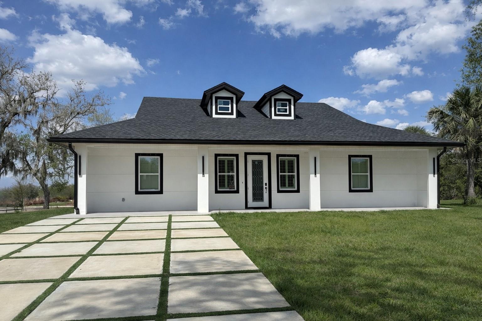 Beautiful brand new 3-bedroom, 2 bath CBS home in Okeechobee featuring 10-foot ceilings and a spacious covered front porch perfect for morning coffee and sunset views. The kitchen offers tall wood cabinets, quartz countertops, and stainless-steel appliances. Interior highlights include tile floors throughout, tiled showers, and sleek black fixtures. Enjoy backyard views from the covered rear porch. Impact windows, central A/C, custom closets and doors complete this move-in ready property. Plenty of room for your boat, RV, or toys.