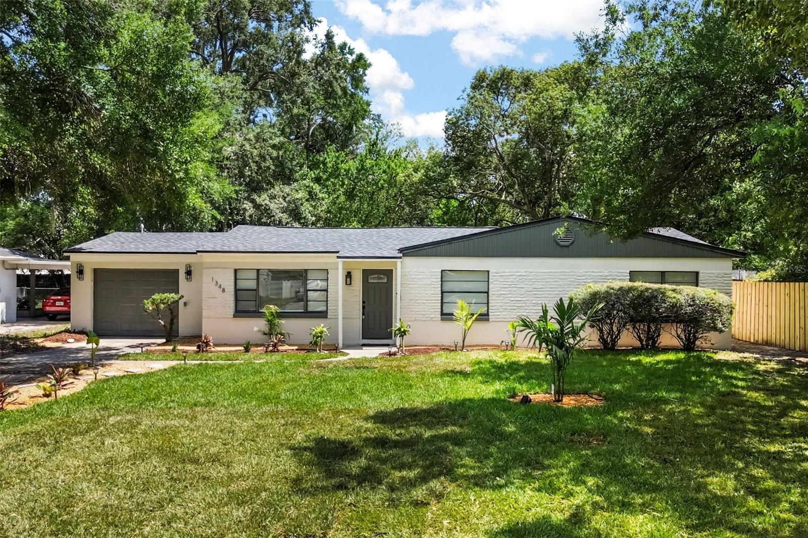 Welcome to 1348 Radclyffe Road, a tastefully designed home at the end of a cul-de-sac in the highly sought-after College Park area of Orlando. This move-in-ready residence features an open-concept layout filled with natural light, updated flooring, modern fixtures, and a stunning fireplace feature wall that creates a warm and inviting focal point within the main living space. The fully remodeled kitchen is designed for both style and functionality with quartz countertops, shaker-style cabinetry, stainless steel appliances, designer lighting, a herringbone backsplash, and a spacious peninsula with bar seating. A dedicated home office provides the flexibility for remote work, study, or additional living space. The primary suite offers a spa-inspired bathroom complete with dual vanities, a freestanding soaking tub, and an oversized walk-in shower, while two additional bedrooms and another beautifully renovated bathroom provide comfortable accommodations with modern finishes throughout. Roof, A/C & water heater all replaced in 2025! Step outside to enjoy a spacious screened-in lanai with exposed wood beam ceilings, brick flooring, and multiple ceiling fans creating the perfect setting for relaxing or entertaining year-round. The expansive backyard is surrounded by mature trees and lush landscaping, offering a private outdoor retreat with endless potential for gatherings, recreation, gardening, or future additions. Thoughtfully updated inside and out with versatile living spaces and exceptional indoor-outdoor flow, this College Park gem is ready to impress. Schedule your private showing today.