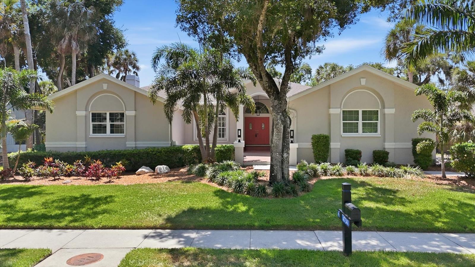Tucked within the lush, oak-canopied community of The Lakes Estates, this beautifully updated 4-bedroom, 3-bath home is set on an oversized lot in one of the area's most picturesque settings. A spacious front courtyard creates a warm welcome before you even step inside, offering the perfect spot for morning coffee, quiet evenings, or a charming garden space. Inside, soaring ceilings, architectural arches, and an airy openness make an immediate impression from the foyer. The formal living room offers a comfortable place to gather or unwind, while the separate dining room is perfectly positioned for everything from holiday dinners to casual evenings with friends. At the heart of the home, the impressive main living area feels inviting and anchored by a fireplace, with sliding doors opening to the expansive screened lanai. The kitchen is open and well-connected, featuring resurfaced cabinetry, NEW quartz countertops, NEW stainless steel appliances, space for bar seating, and a bright dinette for everyday meals. The split-bedroom layout creates privacy, with the primary suite tucked into its own corner of the home offering direct lanai access, two walk-in closets, and an en suite bathroom with dual vanities, a soaking tub, and a NEW shower. Two additional bedrooms are positioned on the opposite side of the home, while the fourth bedroom is tucked along the primary wing, offering flexibility for guests, family, or a home office. Two additional bathrooms are wonderfully updated and feature NEW cabinetry, counters, and showers. AC was replaced in 2021 with the 2 hot water heaters replaced 2022. Fresh paint inside and out make this jewel truly move-in ready. Outside, the expansive screened lanai spans the back of the home, while the large NEW Trex deck creates an ideal space for grilling, outdoor dining, or gathering around with friends, all overlooking a spacious backyard complete with a built-in fire pit on a rare .4-acre homesite. A 3-car side-load garage adds even more practicality, while The Lakes Estates offers residents access to two community pools, tennis courts, a clubhouse, walking trails, and lakefront common spaces woven throughout this beautifully established neighborhood. With generous indoor and outdoor living space, meaningful updates, and a setting surrounded by mature greenery, this is a home designed to be enjoyed for years to come.