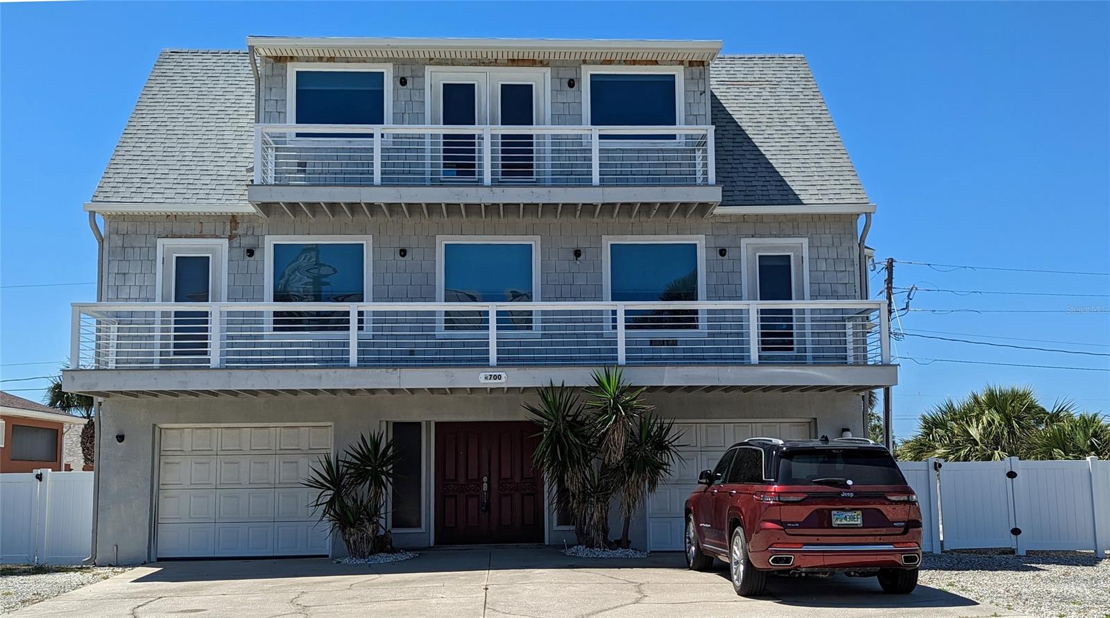 The vacation home you have been waiting for! With a little TLC, this could be a showplace. Very well constructed by a CEO at Disney for his own vacation retreat, this house has been updated by the previous owner to include: New Impact glass windows and doors (those that could not have impact glass have hurricane shutters) for protection from storms 2018. Also a whole house 16 KW Generac generator with propane tank installed 12/2018, New electric panel box 2022, new 1.5 ton Coastal A/C system 2018. New composite decking and SS railings 2015. The main entrance is flanked on both sides by single car garages. Upon entry is a foyer and full bath with shower which can be accessed from the pool through the garage. Large covered back lanai connecting to the large in-ground pool in the private walled back yard. Second floor houses the main living areas and front and back balconies. The 28' LR can be closed off with the accordion room divider to provide a 3rd BR or office/guestroom which would measure 13X13 making the LR now 15X15. The other BR on this floor has a huge wall-length closet with more storage from it going under the stairwell, and a new exterior door to the back balcony. In the hall is the guest bath with 2 sink areas. Enjoy the very large laundry room with dumbwaiter coming up from garage, which also opens into the all SS appliance kitchen. Lots of custom storage in the kitchen cabinets. The third floor is the MBR ensuite retreat with ocean views and a house wide private balcony . Large bath with double vanities, separate tub and shower, walk in closet. With just a little imagination, and TLC this could be your showplace on the most desirable ocean front street in New Smyrna Beach. ;Water: City